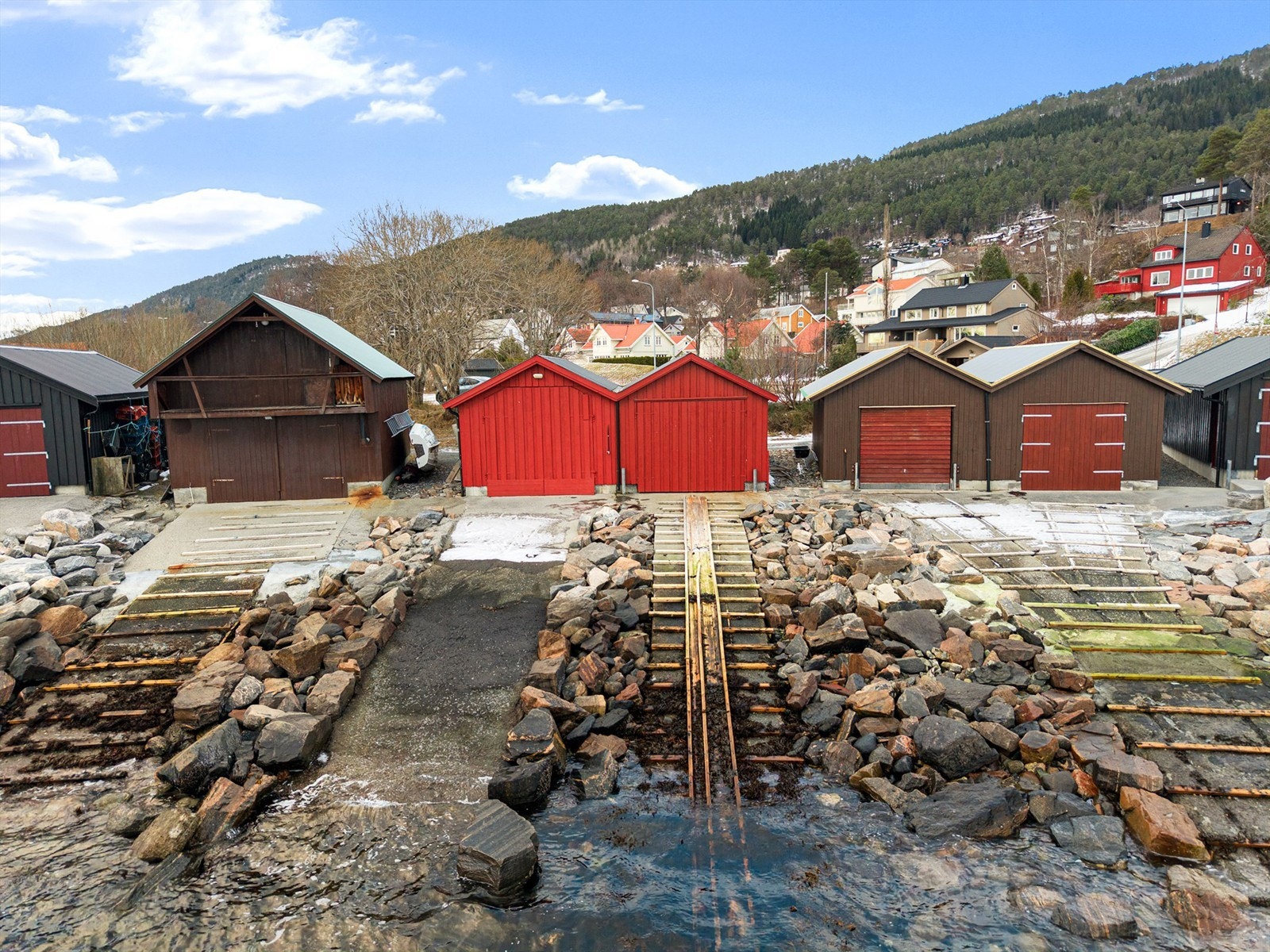 Rødt naust med tilhørende båtstø med trestokker Galleribilde