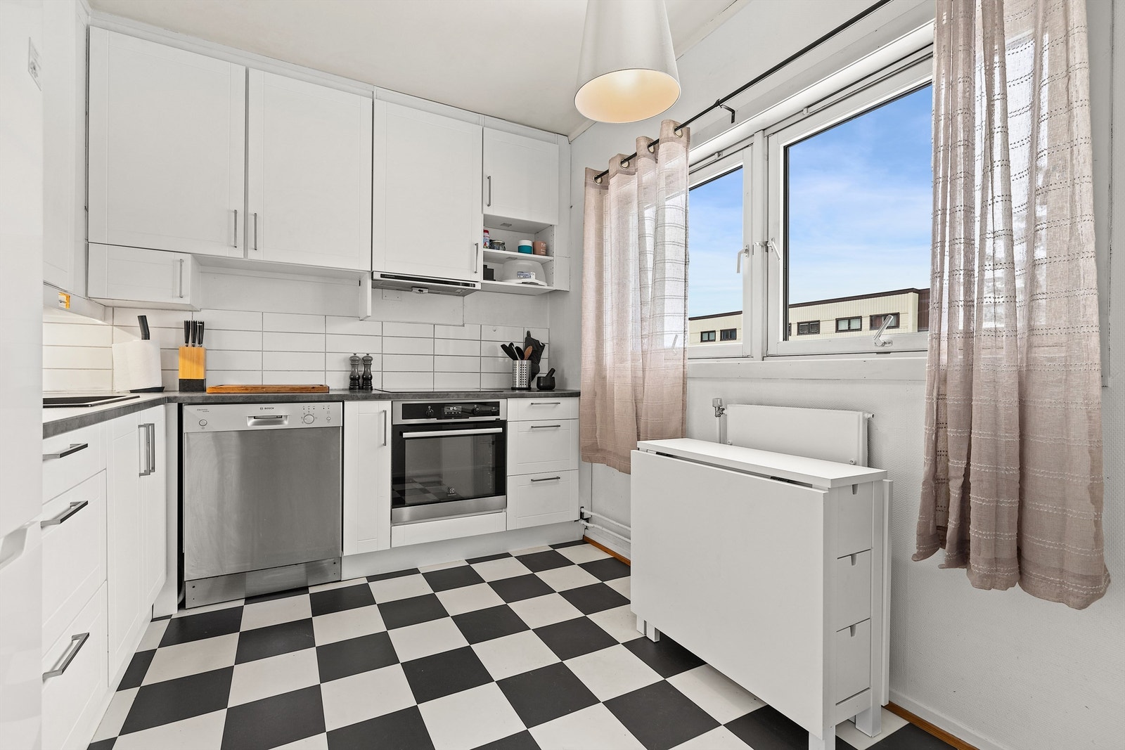 Kjøkken med integrerte hvitevarer som stekeovn, koketopp og opplegg for oppvaskmaskin Galleribilde