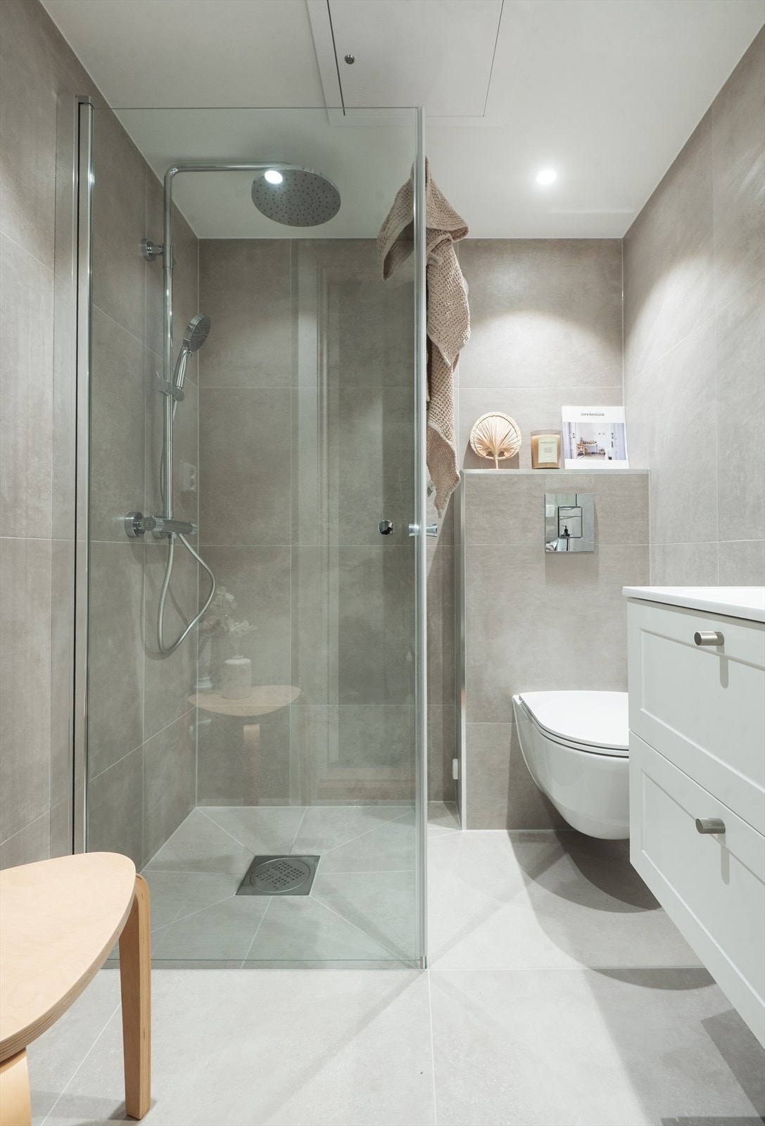 Badet er utstyrt med servantskap, opplegg for vaskemaskin, veggmontert wc og dusjhjørne med glassdører Galleribilde