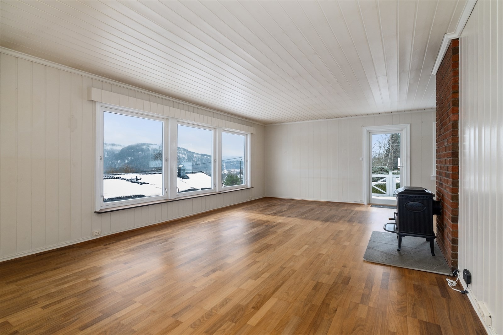 I stuen er det vedovn for lun varme på kaldere dager. Det er i tillegg varmepumpe fra 2023 som varmesupplement. Galleribilde