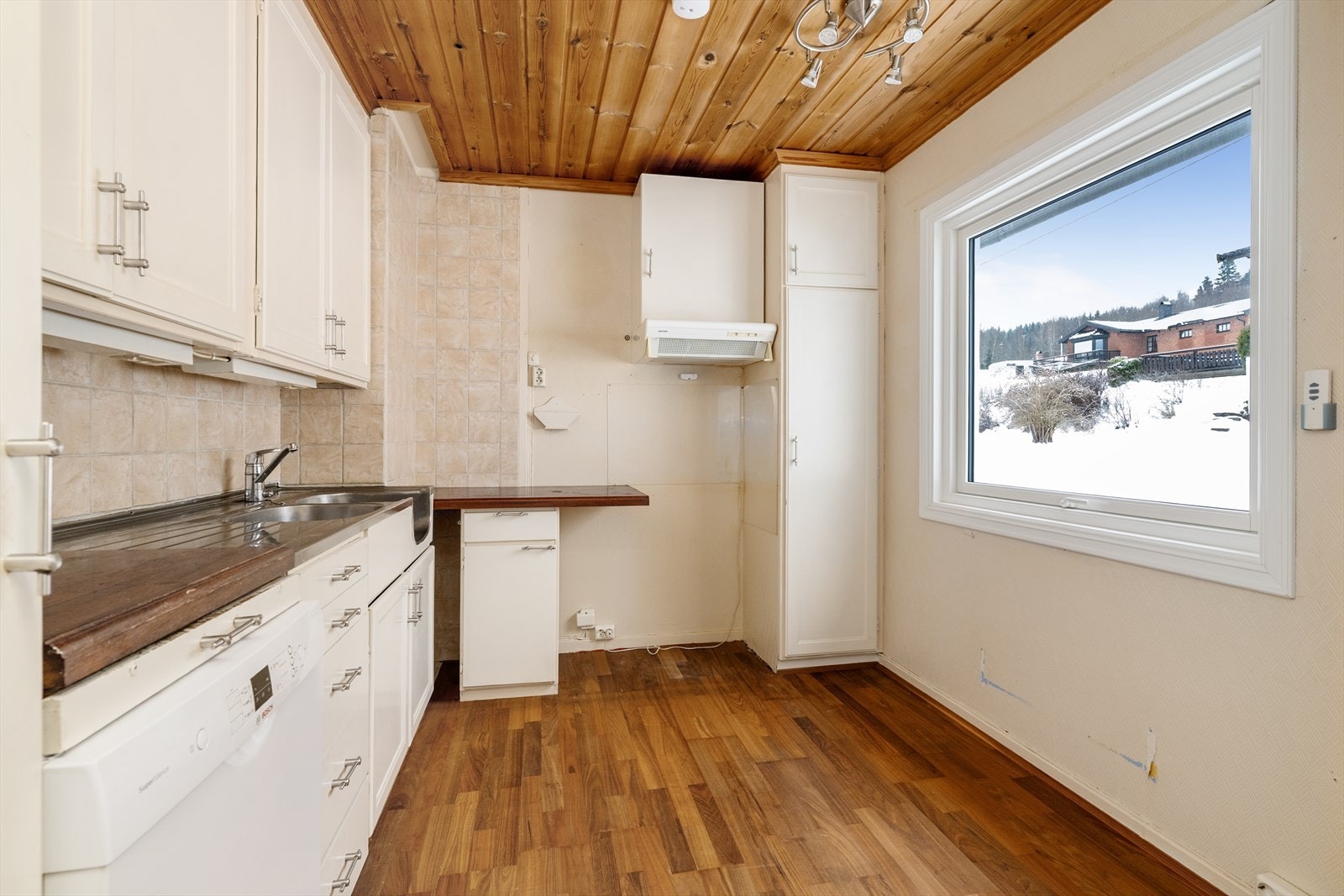 Kjøkkenet har eldre innredning med profilerte fronter og heltre benkeplate med flis over. Det er ventilator over kokesone, samt plexiglass og komfyrvakt. Galleribilde