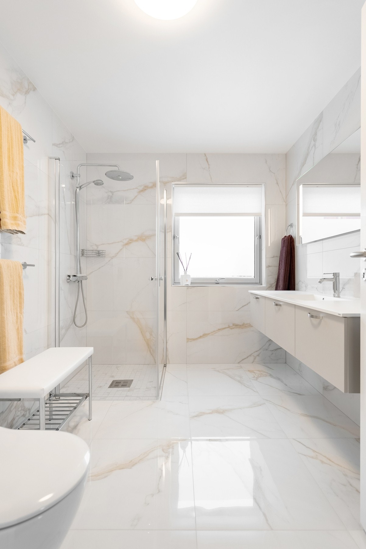 Badet er innredet med veggmontert toalett, dusjhjørne i glass samt 160cm servantmøblement fra HTH Galleribilde