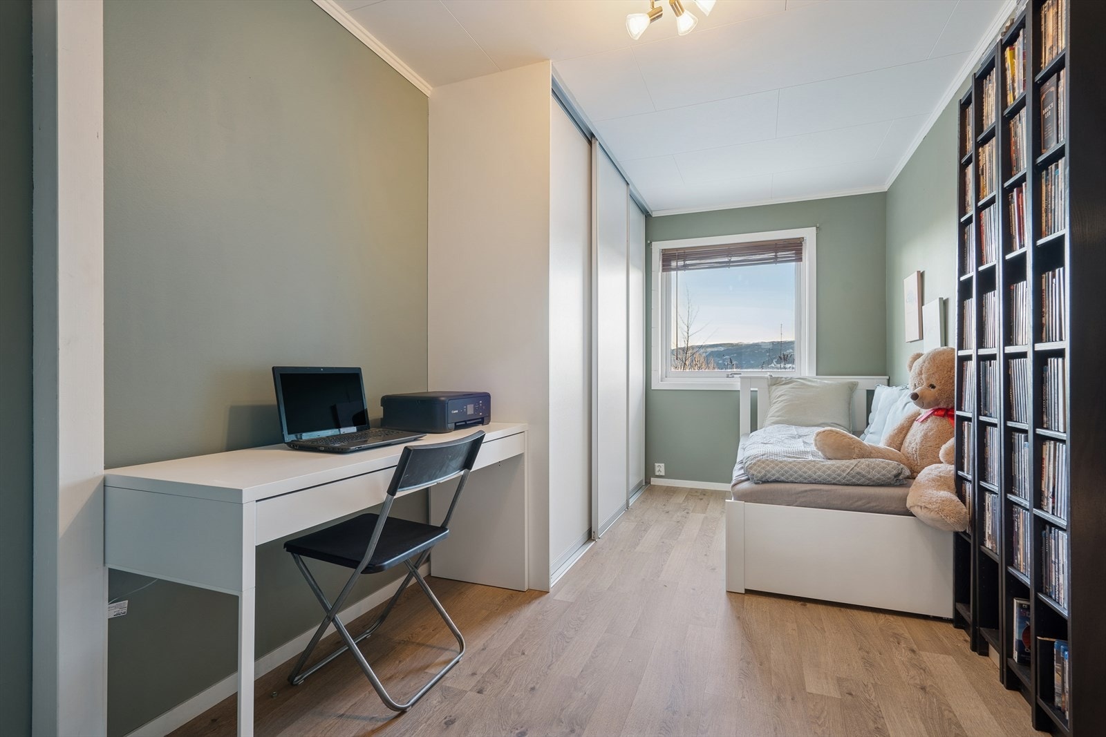 Lyst soverom med arbeidsplass og rolige fargetoner. Galleribilde