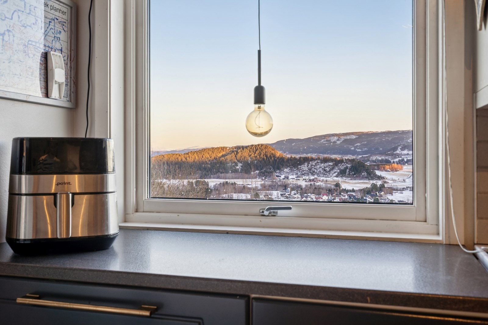 Utsikt fra kjøkkenvinduet med nydelige solnedgangsfarger. Galleribilde