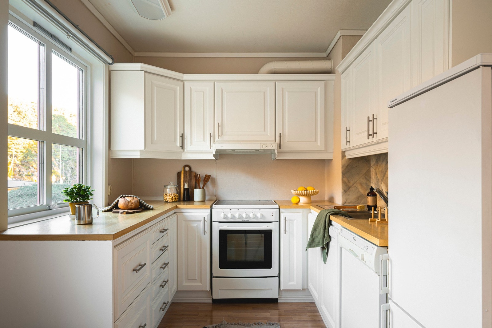 Kjøkkeninnredningen består av profilerte fronter, laminat benkeplate, over benkeplaten er det benyttet malt strie, stål oppvaskkum og ventilator. Galleribilde