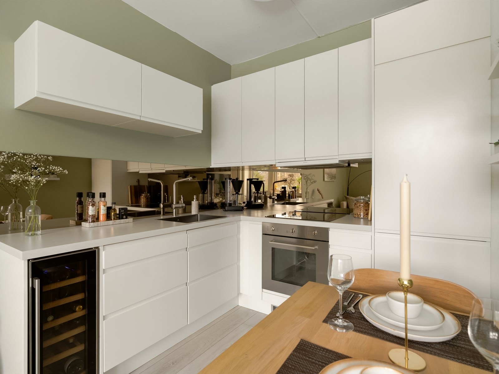 Lekkert kjøkken med vinskap, laminat benkeplate og moderne kitchenboard med speilflate. Galleribilde