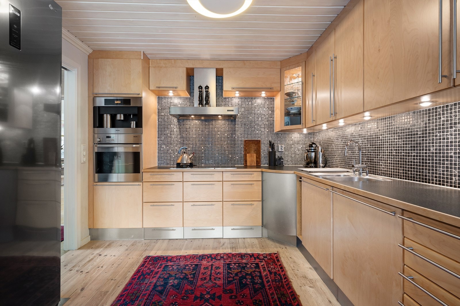 Kjøkkeninnredning med finerte fronter og laminat benkeplate. Galleribilde