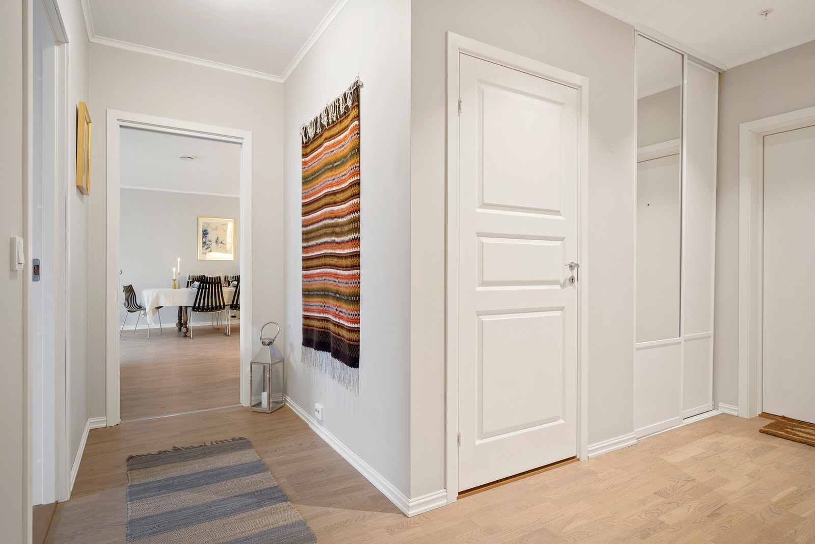 Lys og innbydende entré med slitesterk hvitlakkert eikeparkett og malte veggflater. Galleribilde