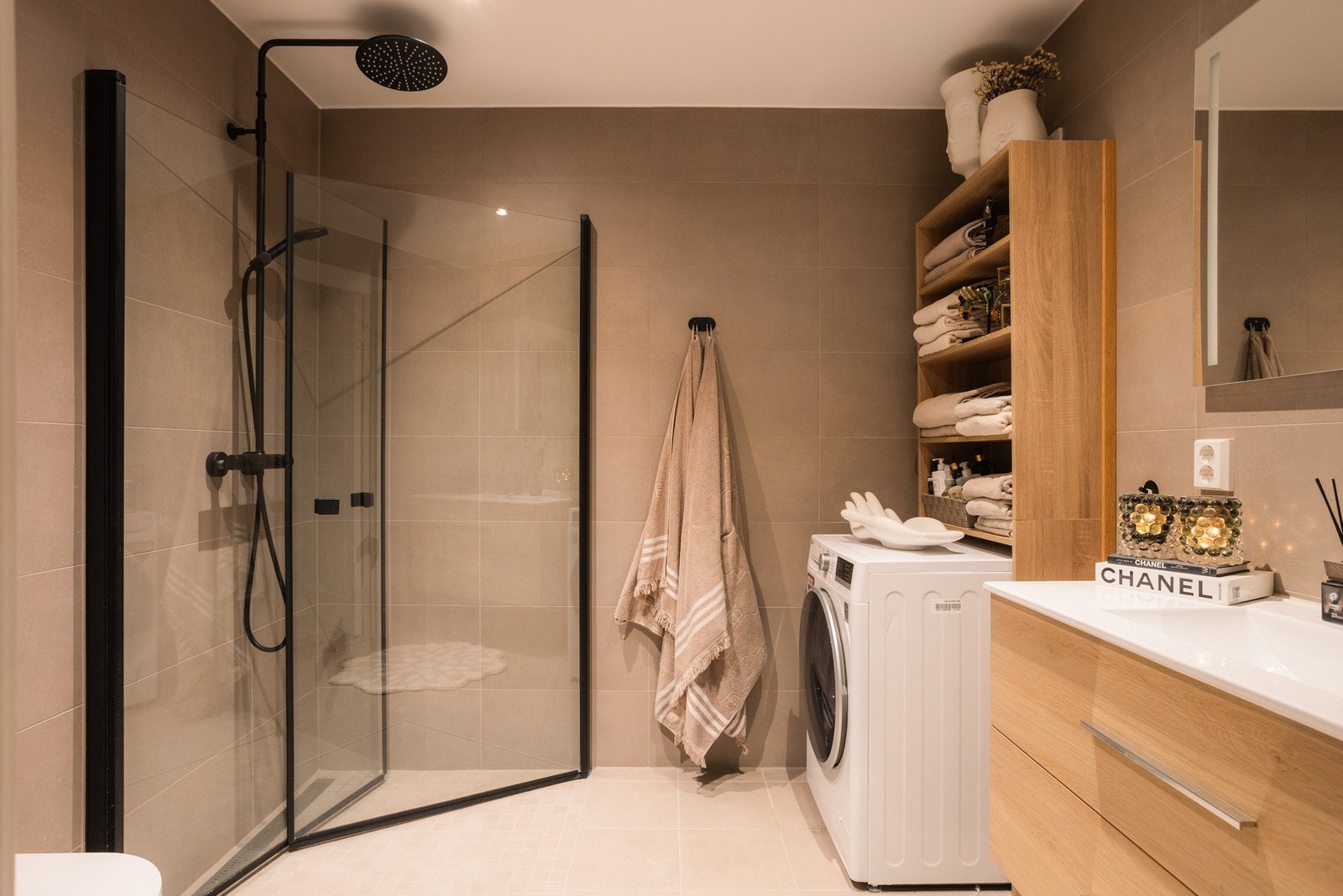 Baderommene har en elegant beige flisepakke, baderomsinnredning i lys eik, dusjhjørne i glass og aluminium og vegghengt toalett. Galleribilde