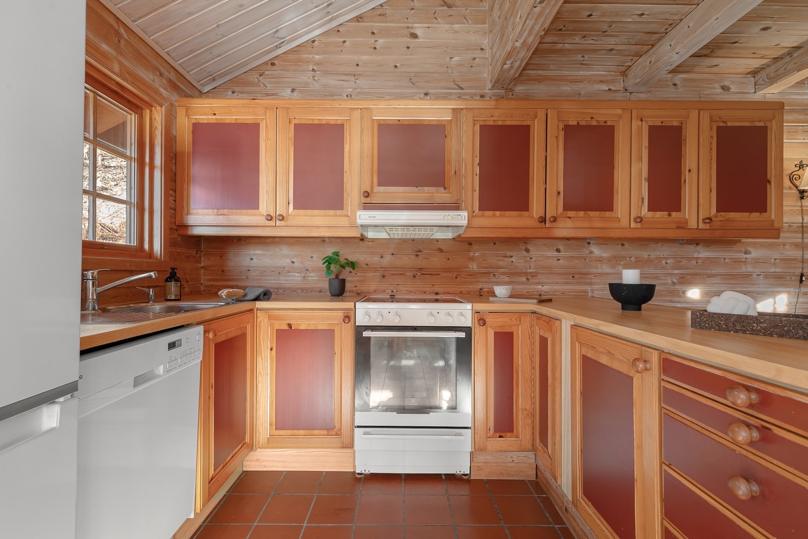 Kjøkenet har innredning i heiltre og benkeplate i laminat. Kvitevarene er frittståande og inkluderer kjøl/frys, oppvaskmaskin og komfyr Galleribilde