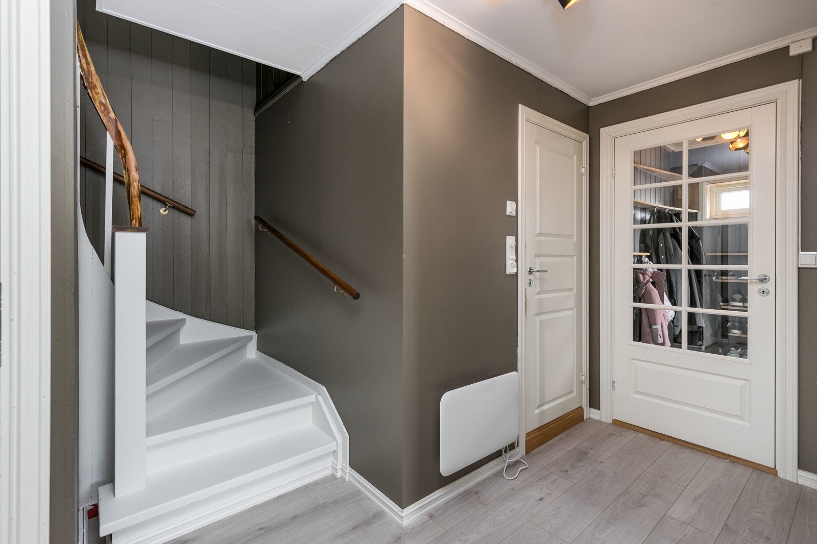 Lys og romslig entrè med vindfang, som gir et godt førsteinntrykk av boligen. Rommet har slitesterkt laminatgulv og malte veggflater. En flott trapp tar deg raskt mellom etasjene. Galleribilde