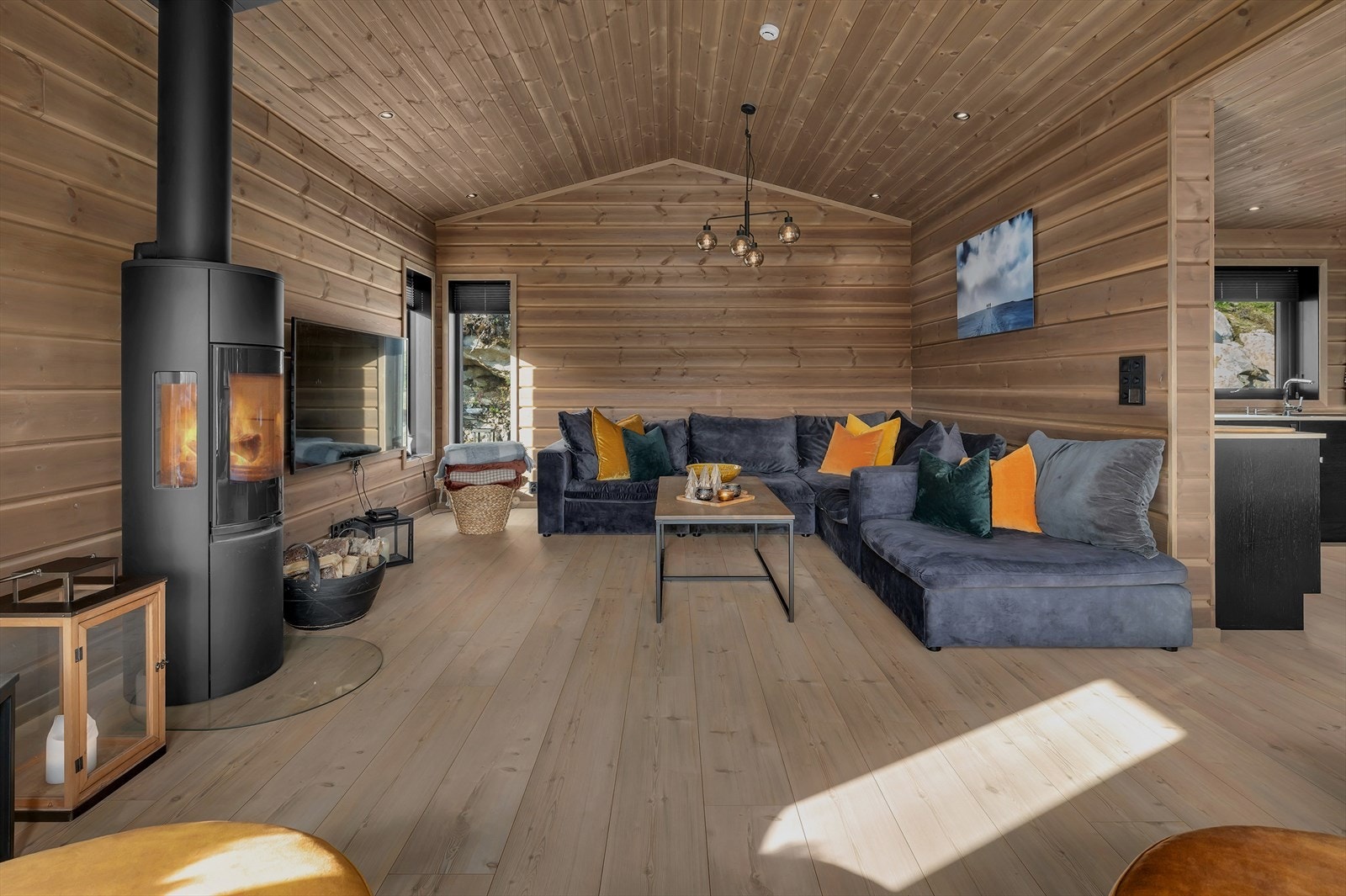 Stova er lun og koseleg med plass til ei større sofagruppe og sitteplass ved utgang til terrassen. Galleribilde