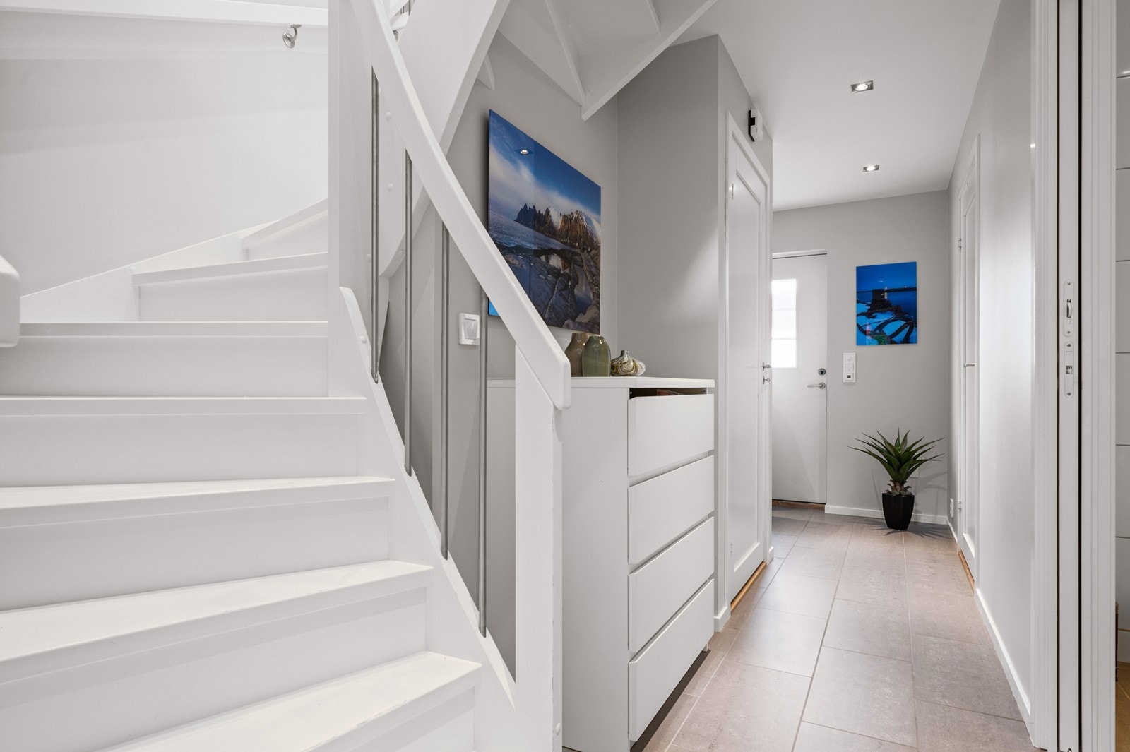 Romslig gang med plass til innredning for yttertøy. Her er det flislagt med varme i gulvet. Galleribilde