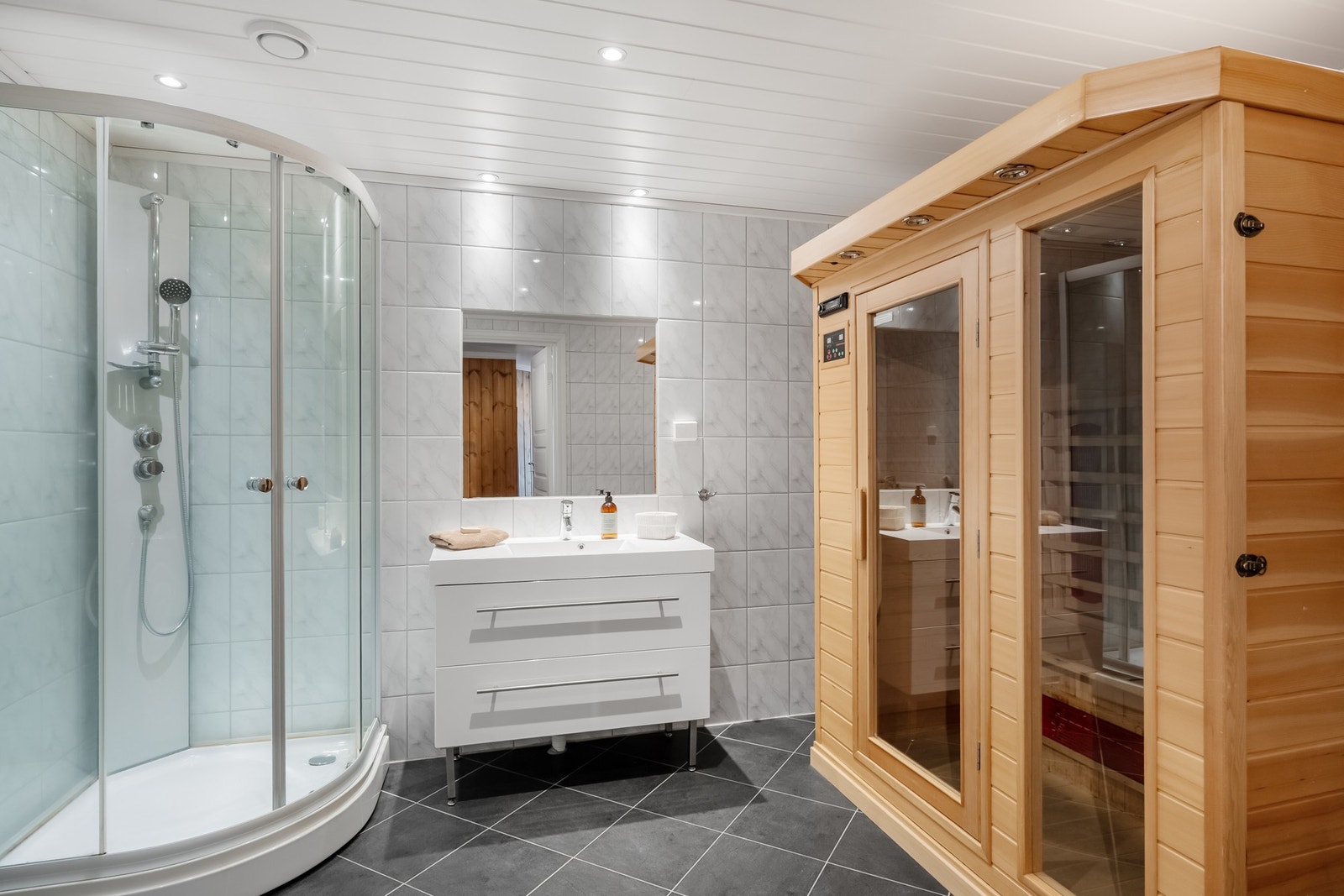 Bad 1 er innredet med servantinnredning, dusjkabinett og opplegg for vaskemaskin, samt frittstående badstue. Galleribilde