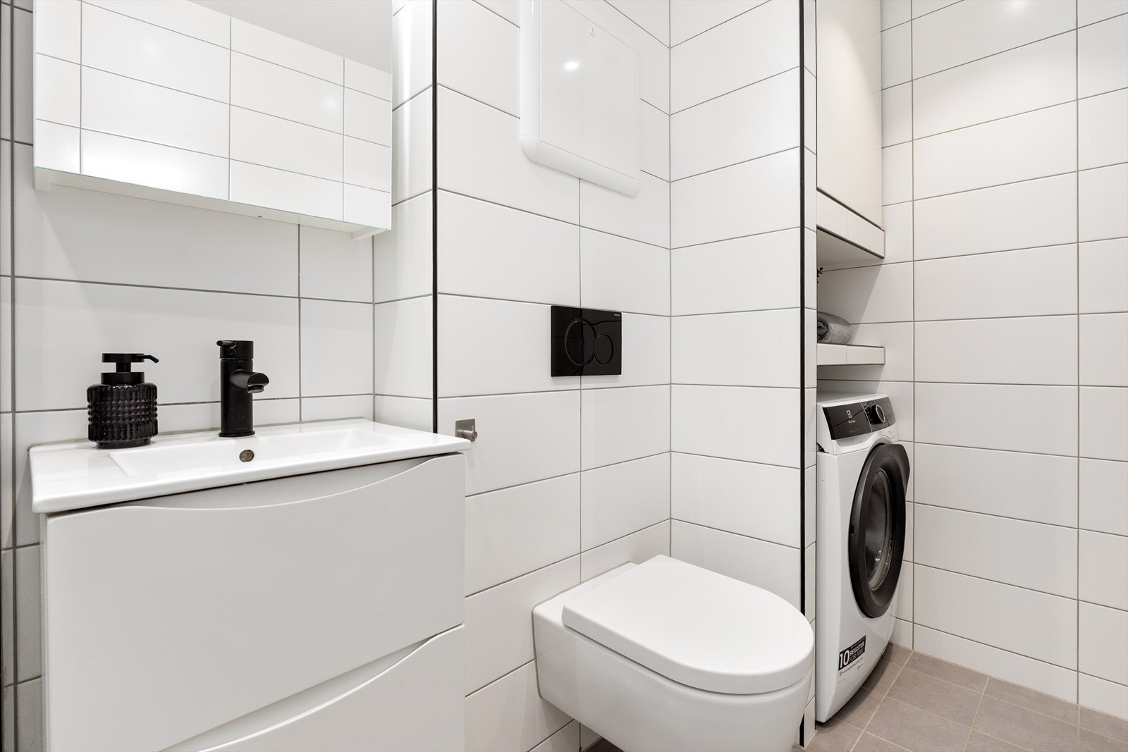 Baderomsinnredning med heldekkende servant og speilskap for ekstra oppbevaring. Galleribilde