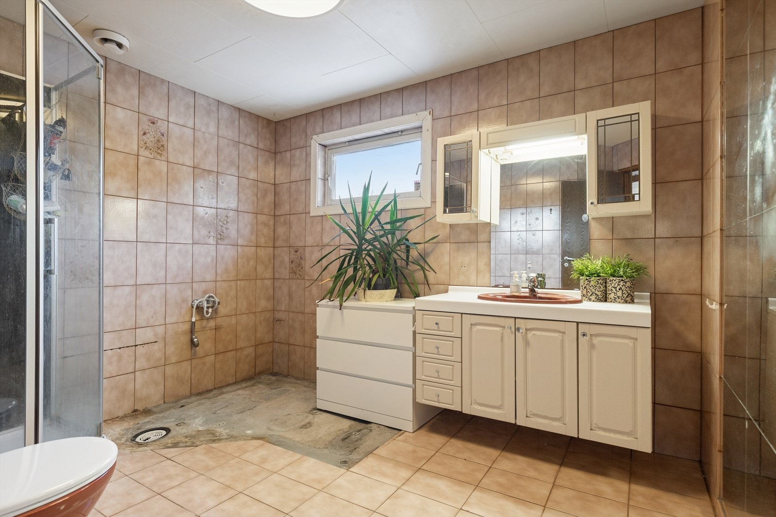 Badet i 1. etasje er i original utførelse fra byggeåret 1983 og har et omfattende behov for oppgradering for å møte dagens krav til våtrom. Galleribilde