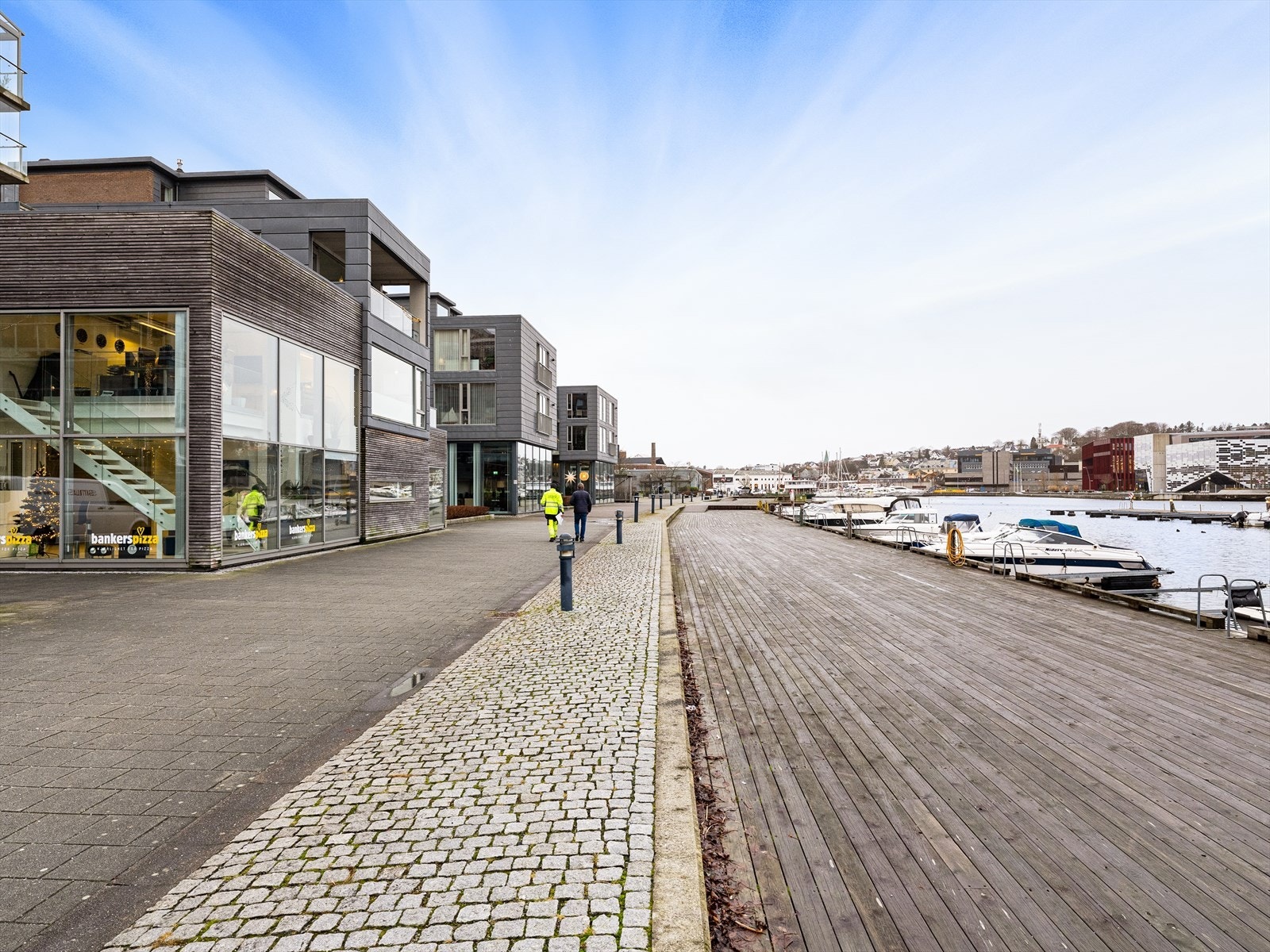 Sjøpromenaden med sittegrupper og samlingspunkt. Volleyballbane på enden. Galleribilde