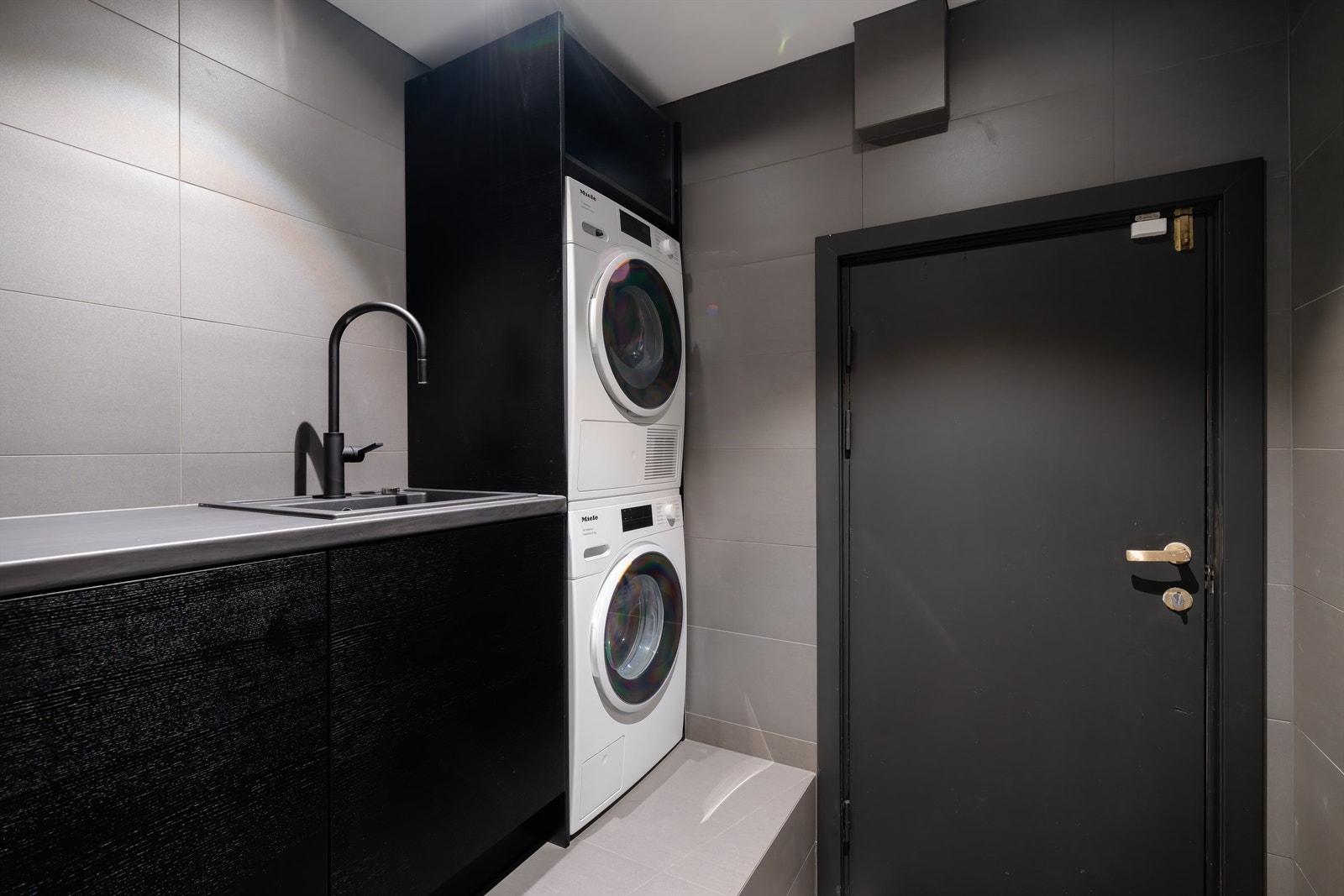 Eget flislagt vaskerom med gjennomtenkte løsninger for maksimal plassutnyttelse. Galleribilde