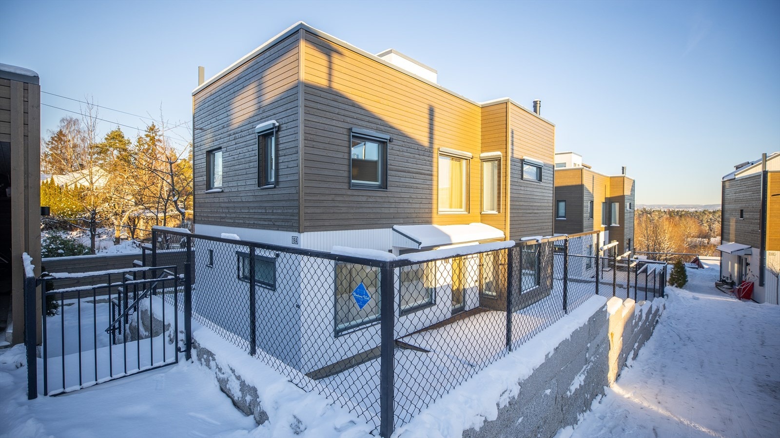 Eiendommen er omkranset av solide støttemurer i granitt, kombinert med sort flettverksgjerde. Galleribilde