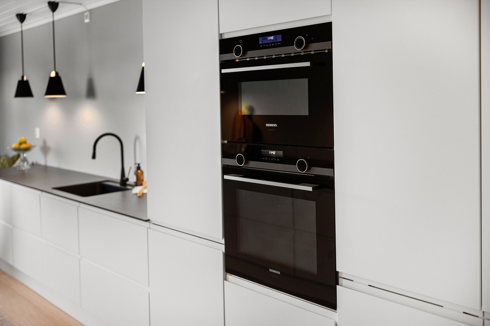 Hvit, stilren og moderne kjøkkeninnredning. Fra 2021. Integrerte hvitevarer. Galleribilde