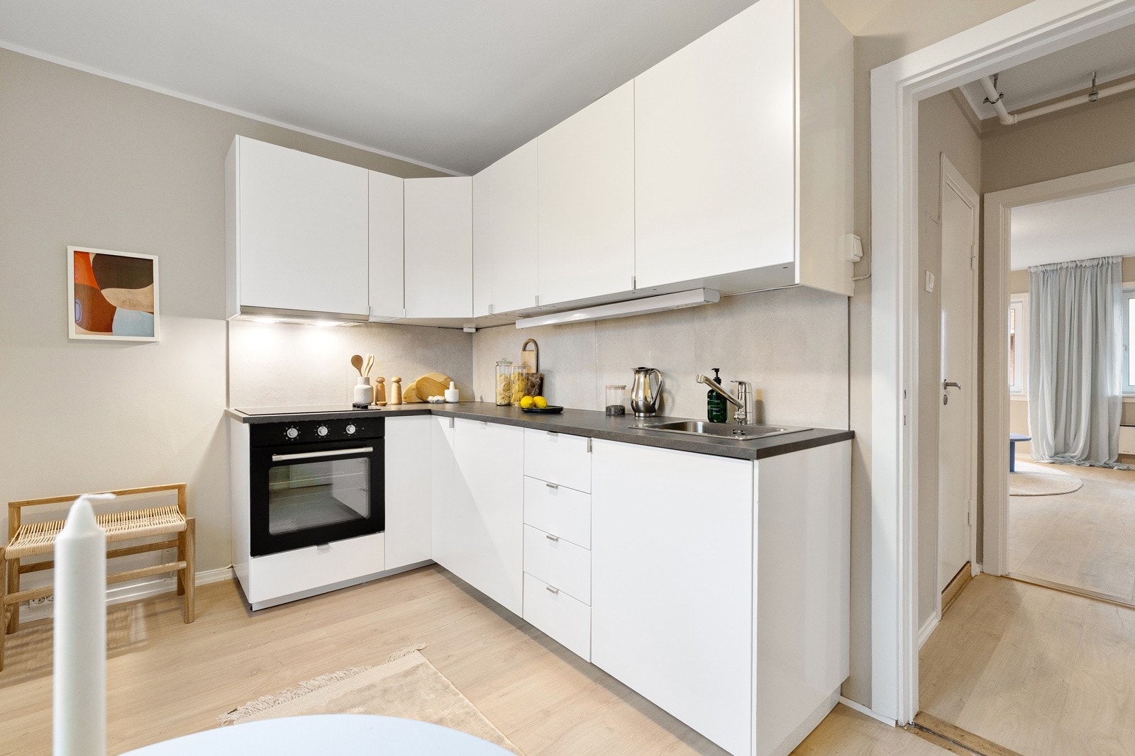 Kjøkkenet er utstyrt med keramisk topp samt integrerte hvitevarer, herunder stekeovn og oppvaskmaskin, som gir et helhetlig og funksjonelt uttrykk. Galleribilde