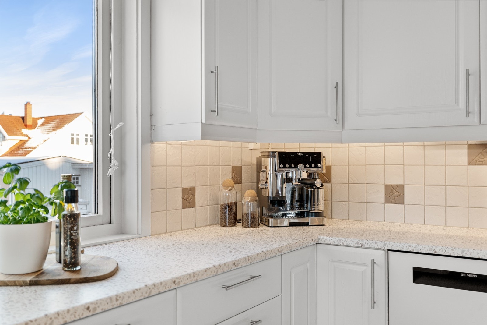 Stilrene fliser over benkeplaten i delikate beige nyanser. Galleribilde