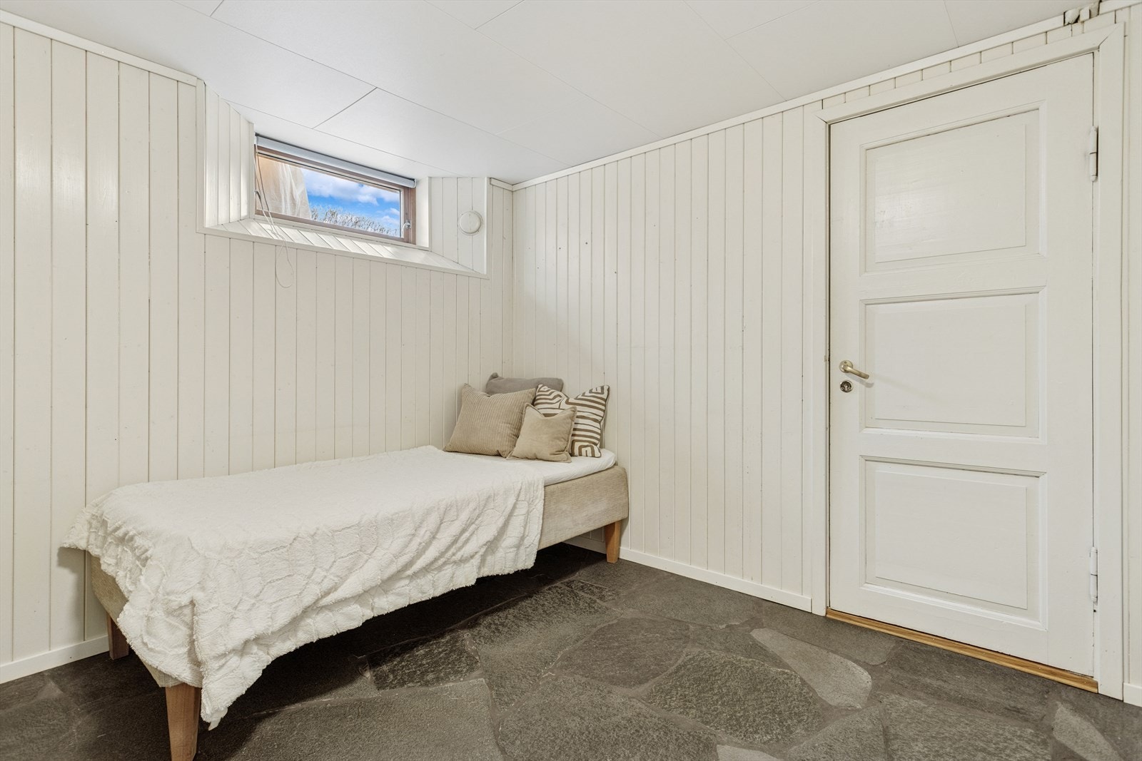 Videre ned i kjelleren er det lagt Oppdalskifer i entreen, nedover trappen og gang/kontorrommet. I dag er rommet innredet som soverom, men dette er ikke søkt om og godkjent. Galleribilde