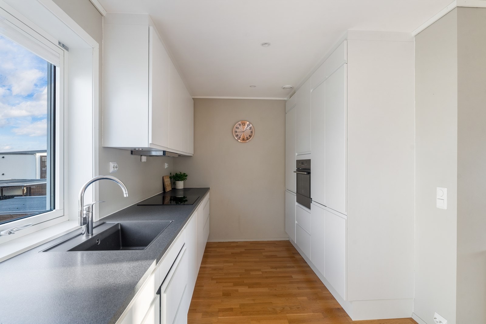 Tidsløst kjøkken med god skapplass og integrerte hvitevarer Galleribilde