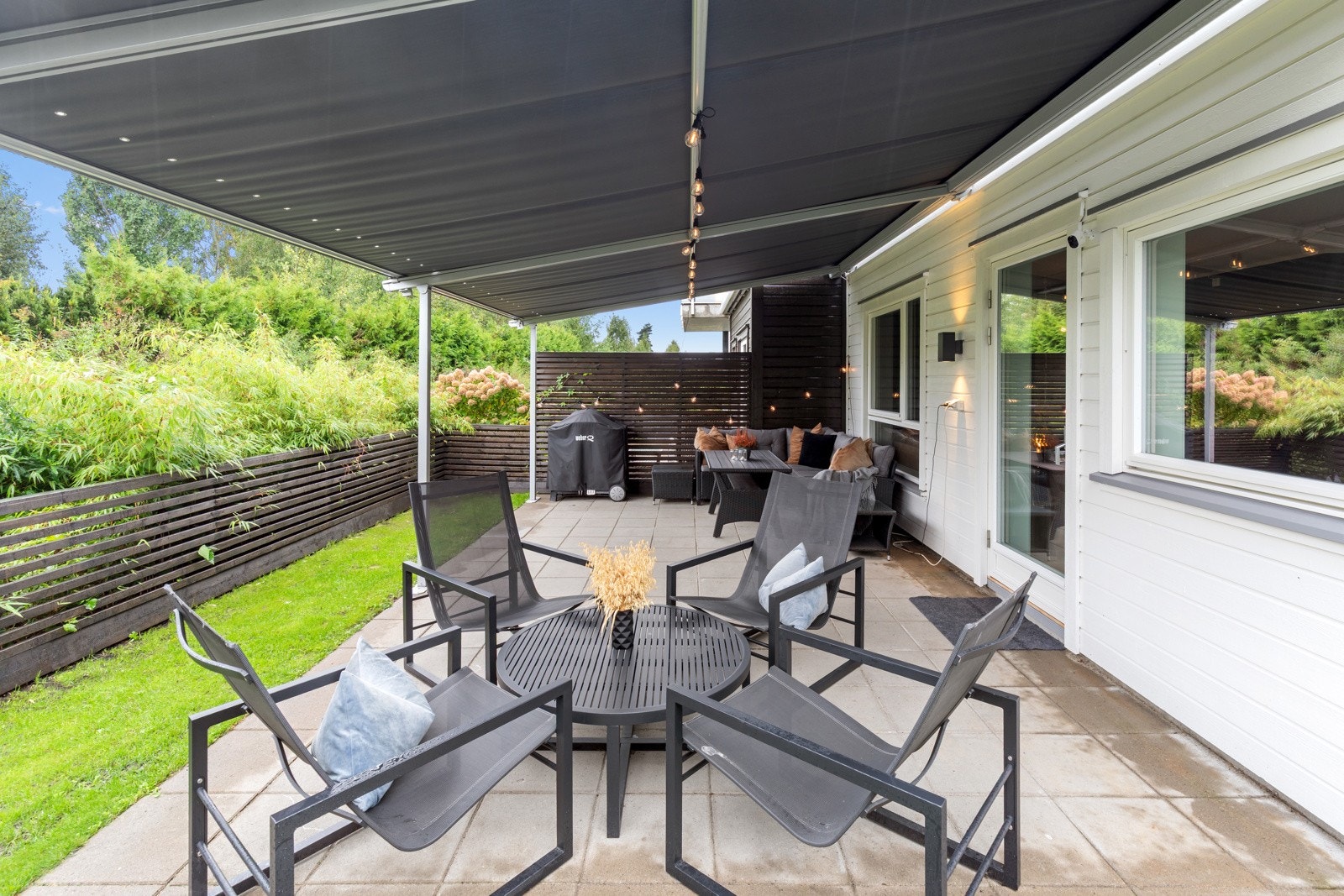 Koselig hellelagt uteplass skjermet med markise. Galleribilde