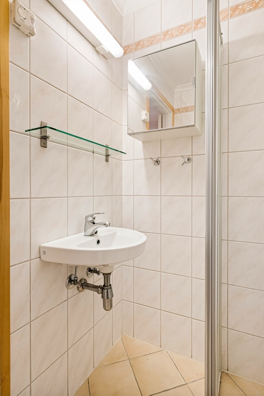 Rommet er innredet med dusjhjørne, servant, speilskap, medisinskap og klosett Galleribilde