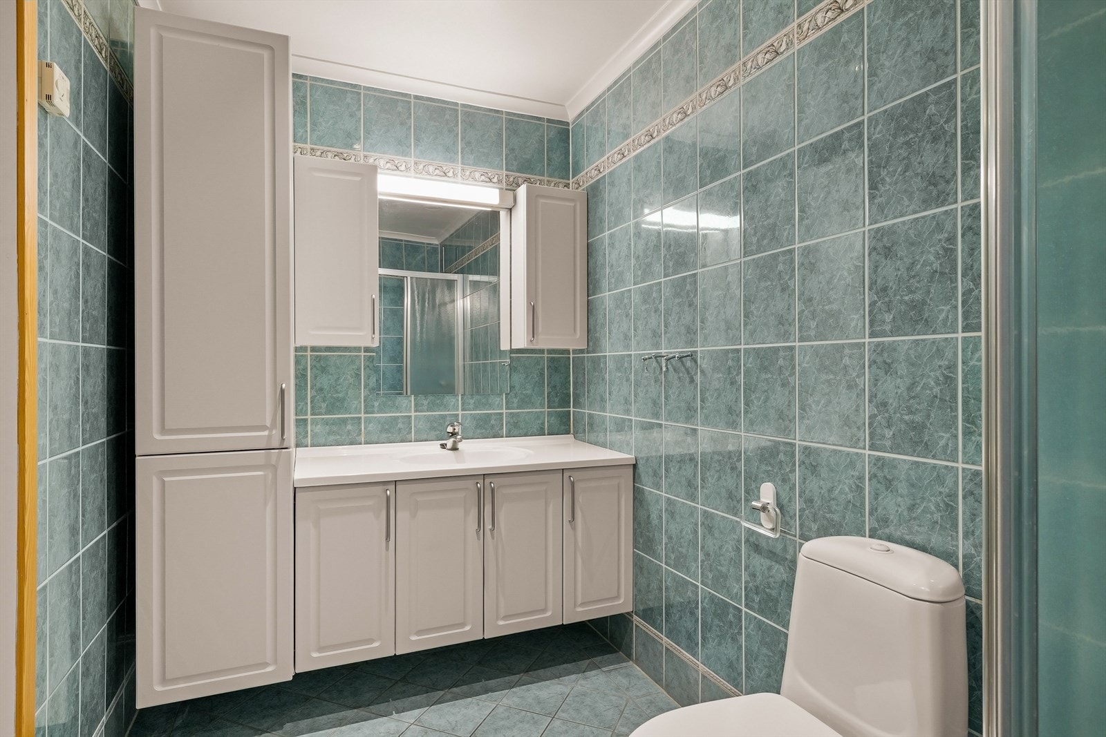 Det er fliser på gulv med elektriske varmekabler, samt fliser på vegger Galleribilde