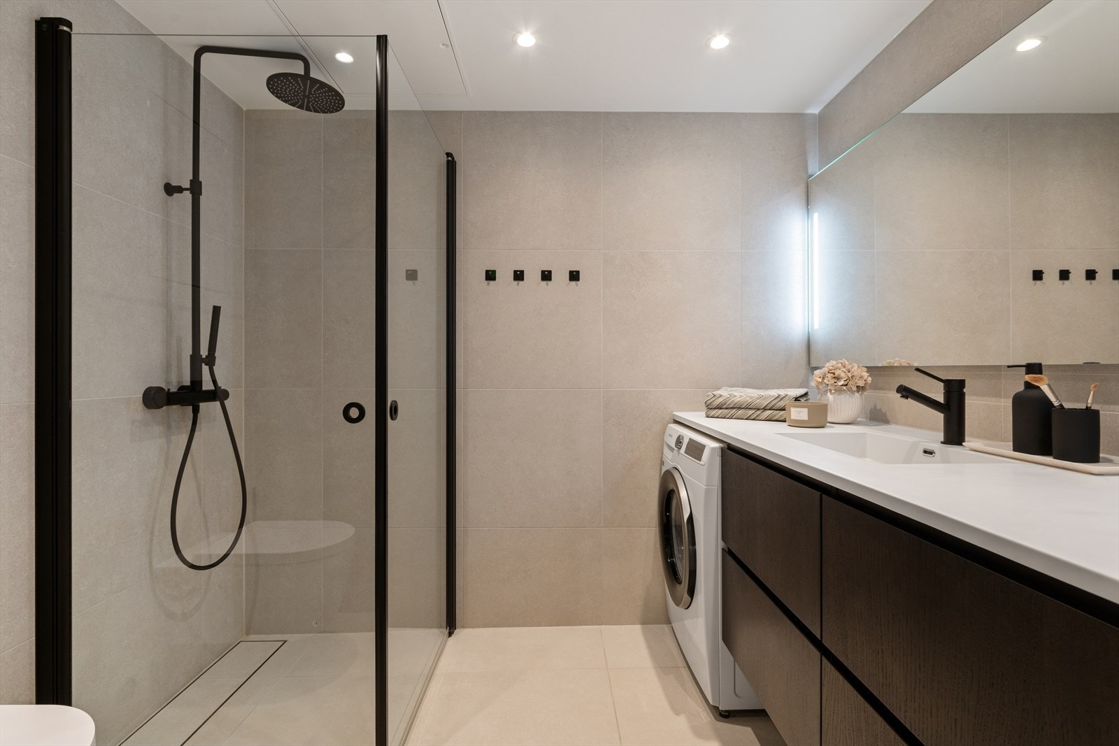 Hovedbadet er flislagt og har elektrisk gulvvarme, dusjhjørne og opplegg for vaskemaskin. Galleribilde