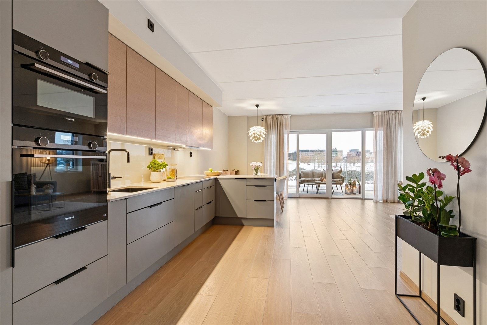 Leiligheten har en åpen stue- og kjøkkenløsning som skaper en sosial og luftig atmosfære. Galleribilde