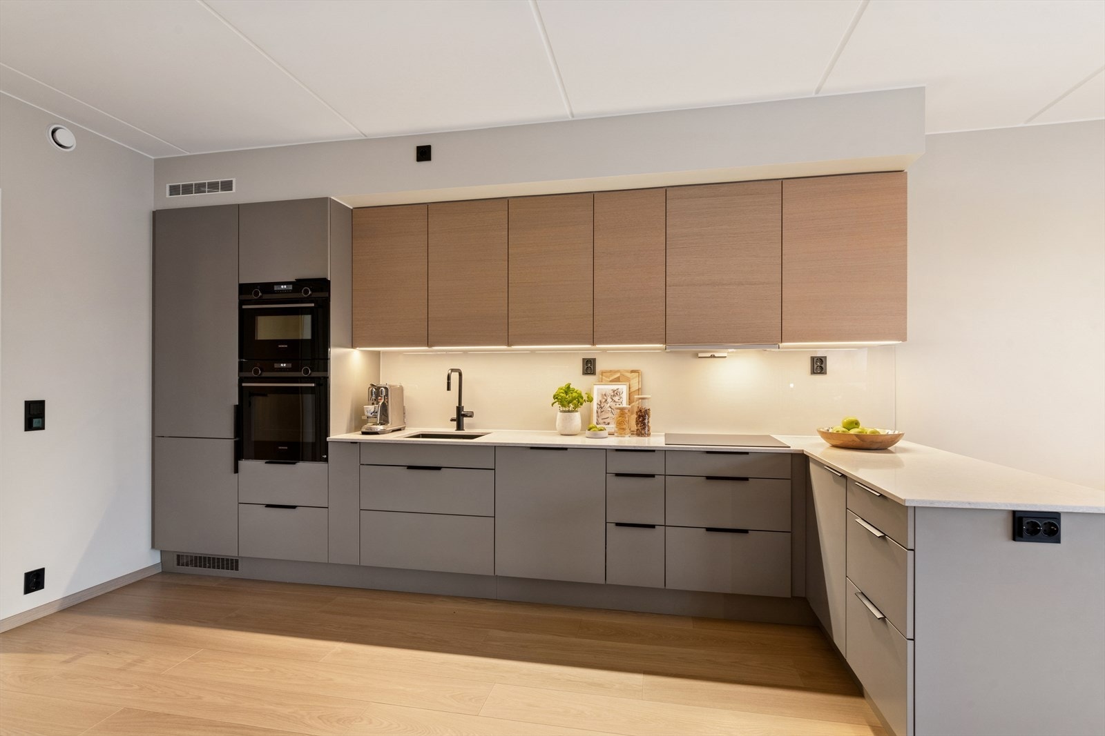 En dør med glassfelt mellom gangen og stuen bidrar til å spre lyset mellom rommene. Galleribilde