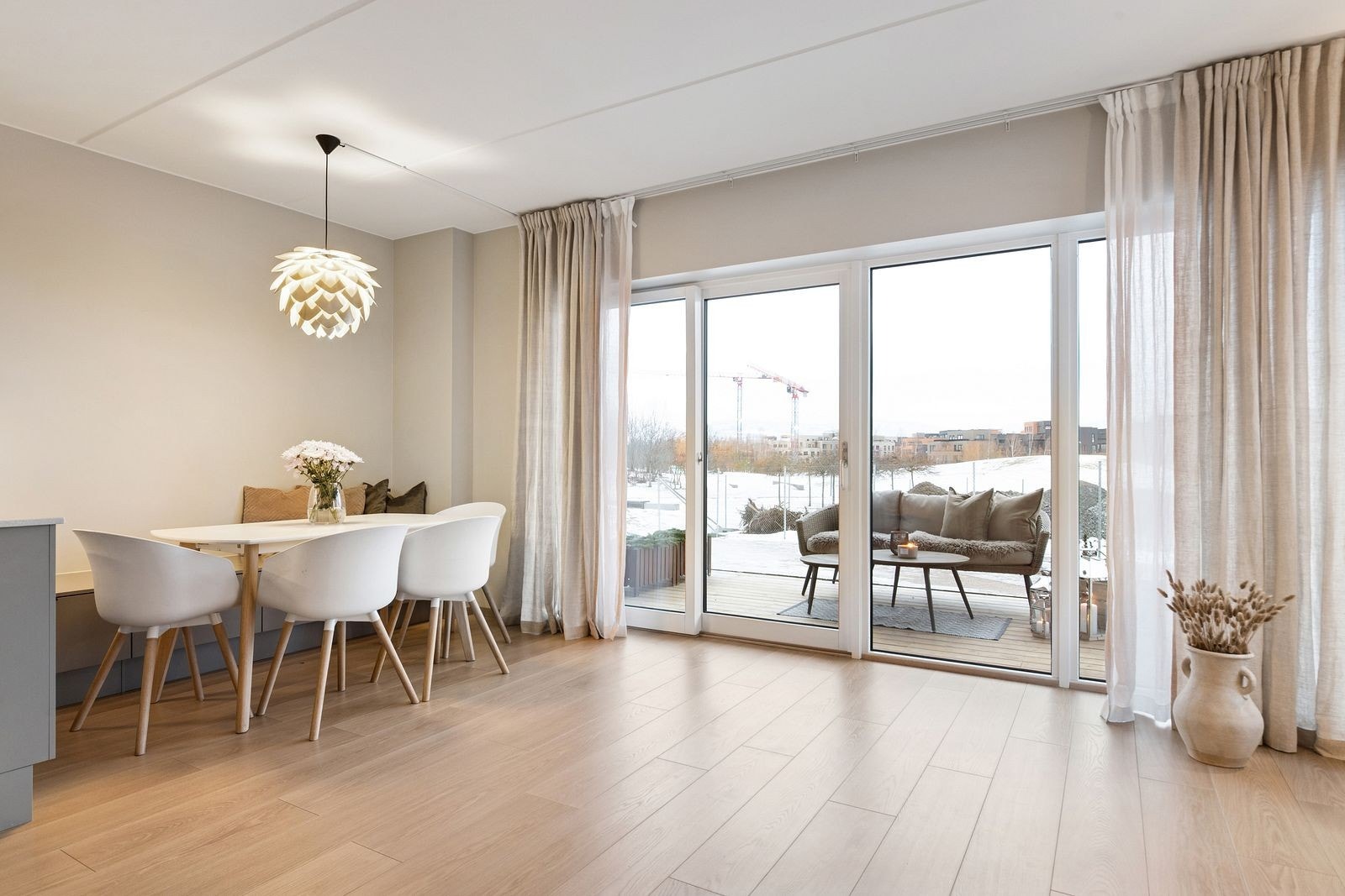 Store vindusflater og skyvedør mot terrassen gir rikelig med naturlig lys til spiseplassen. Galleribilde