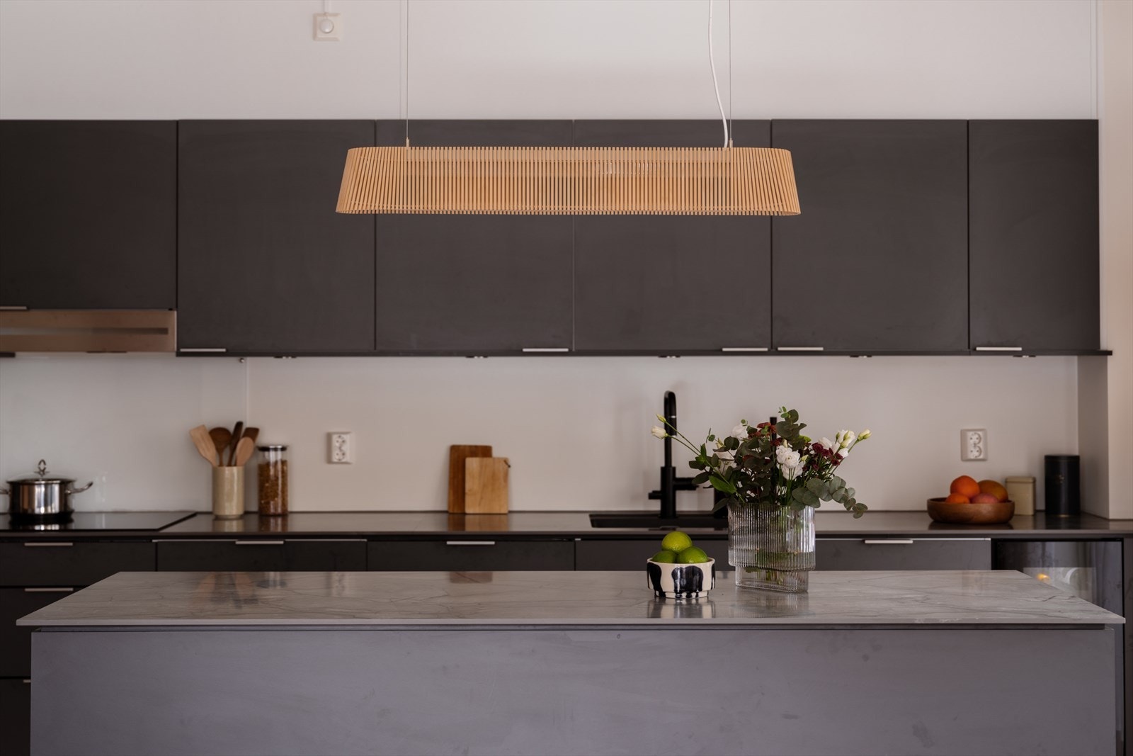 Kjøkkenet, med den store øya, er leilighetens midtpunkt og sosiale arena. Galleribilde