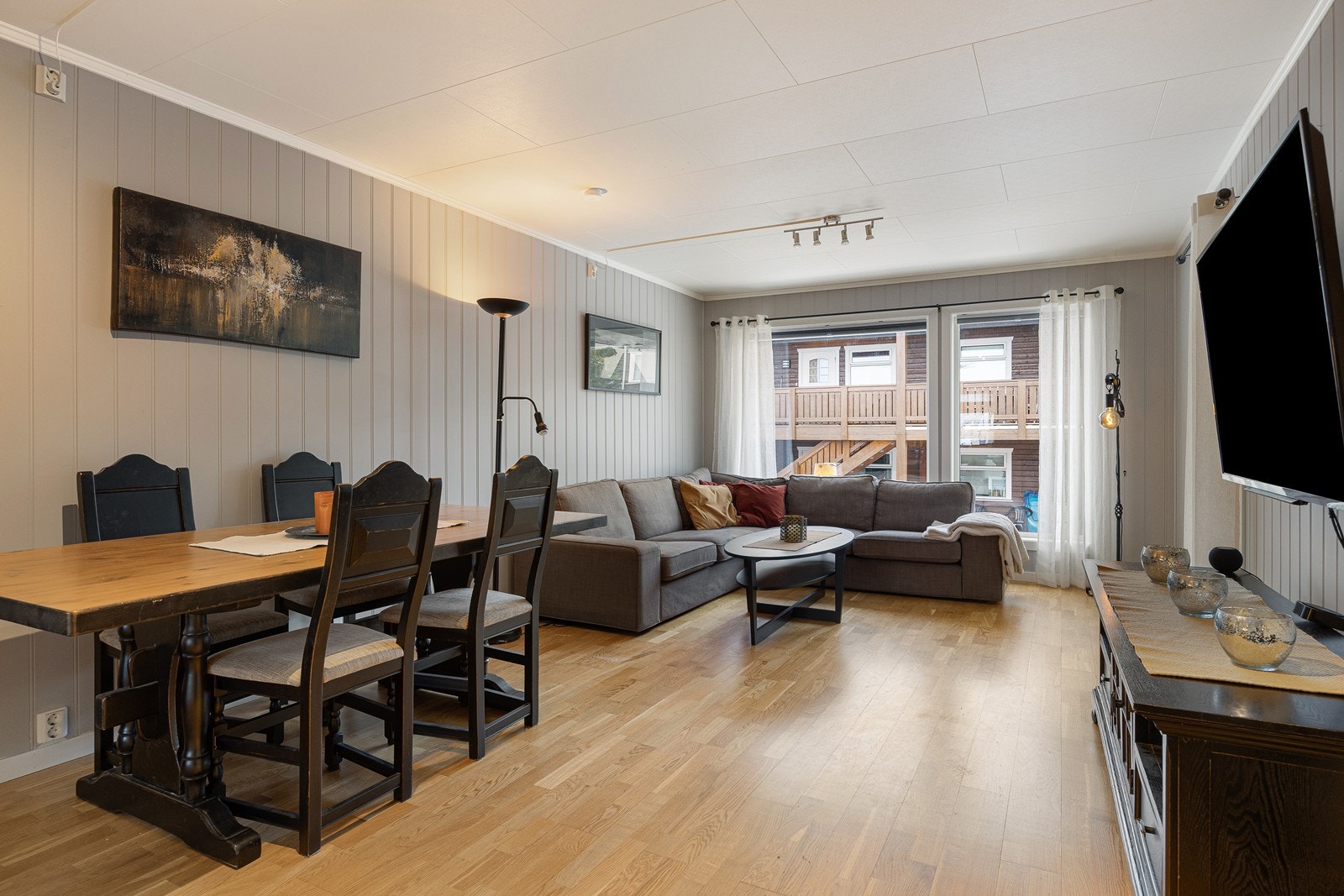 Veggene er malt i en behagelig og dus grånyanse, mens det på gulvvet er lagt gyllen trestavs parkett. Galleribilde