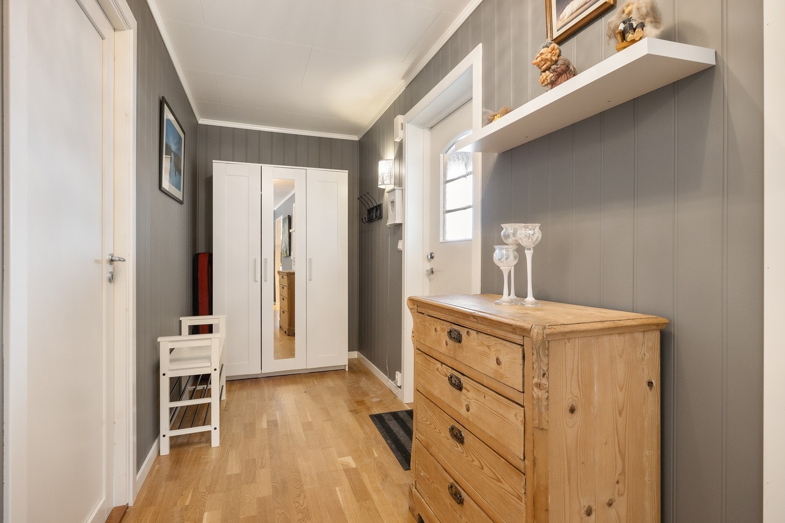 Entréen har gråmalt panel på veggene, som står godt til den gylne parketten på gulvet. Det er fin plass til garderobeløsning. Galleribilde