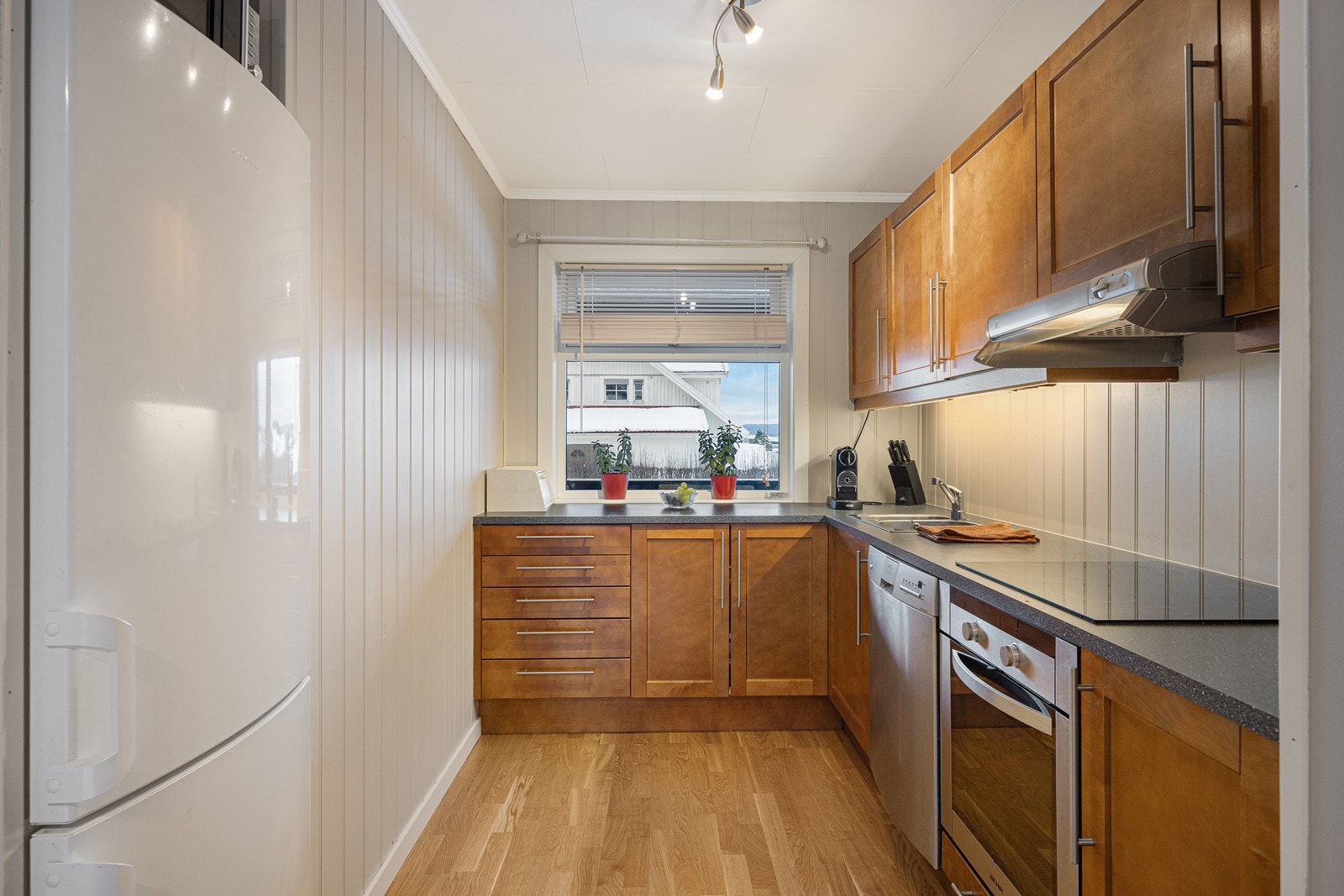 Kjøkkenet har et stilrent og praktisk design med vinkelformet innredning. Galleribilde