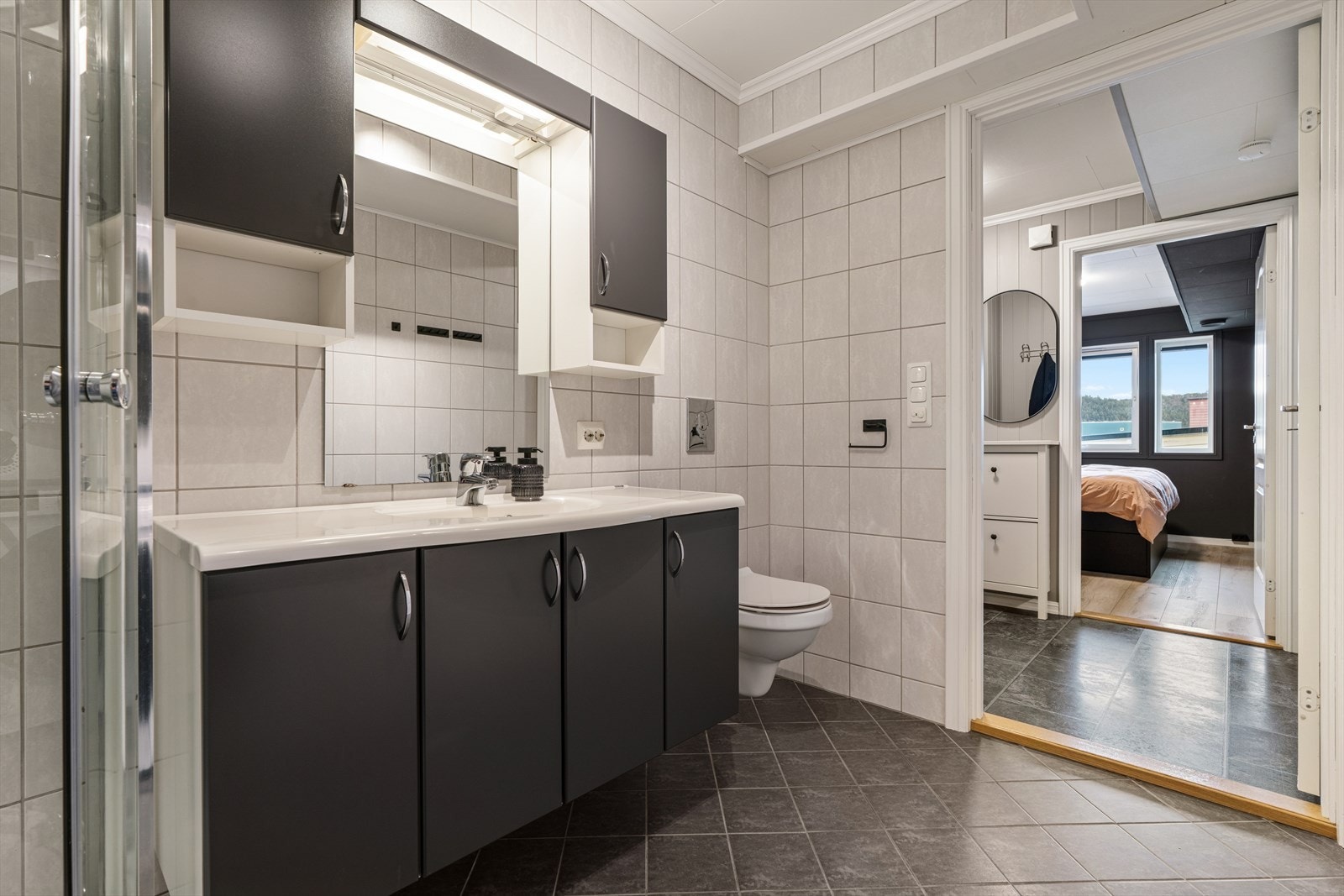 Innredningen består av baderomsseksjon med servant, toalett, dusjkabinett og opplegg for vaskemaskin. Galleribilde