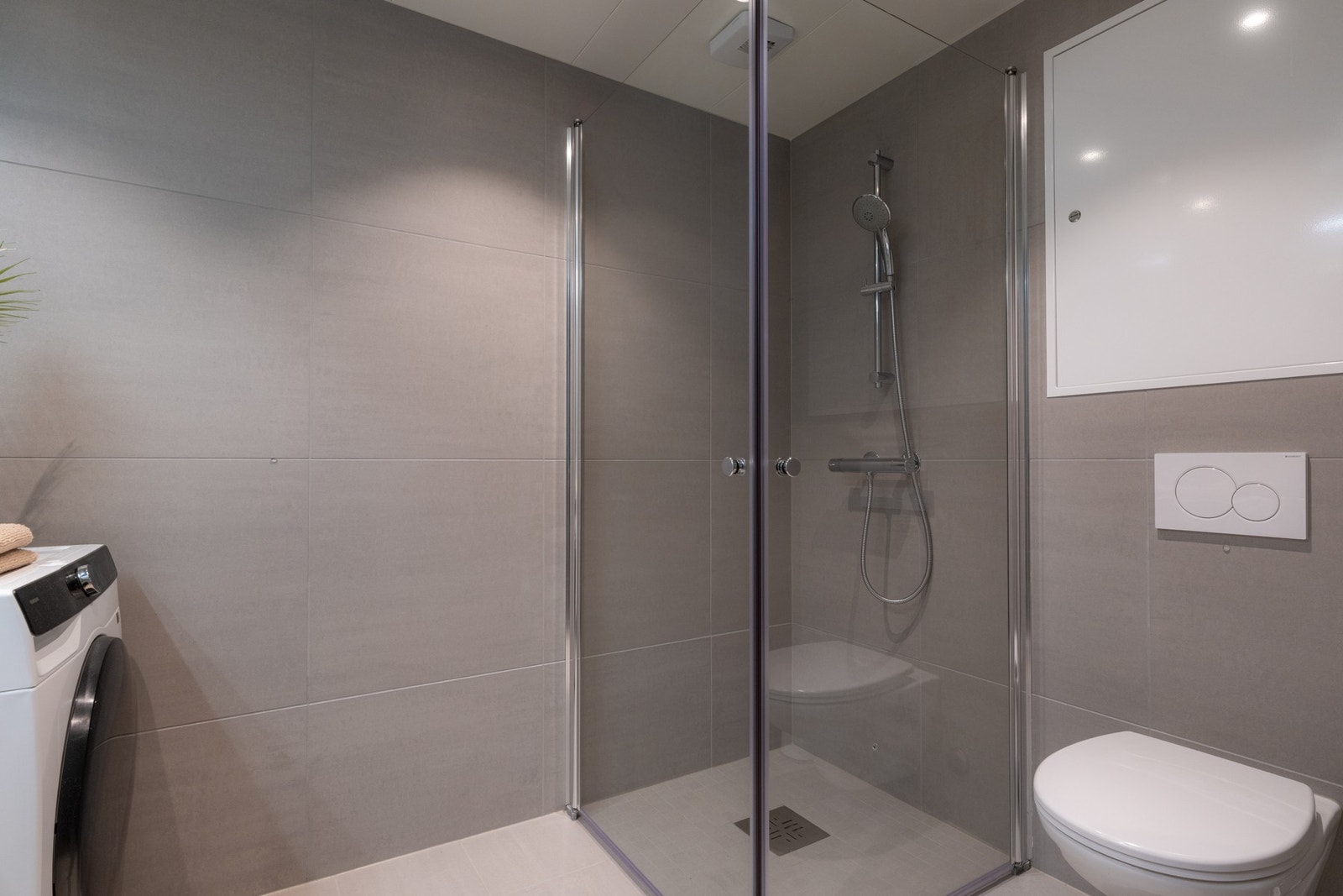 Videre er det vegghengt toalett og dusjhjørne med svingbare glassdører som frigjør plass på gulvet. Galleribilde