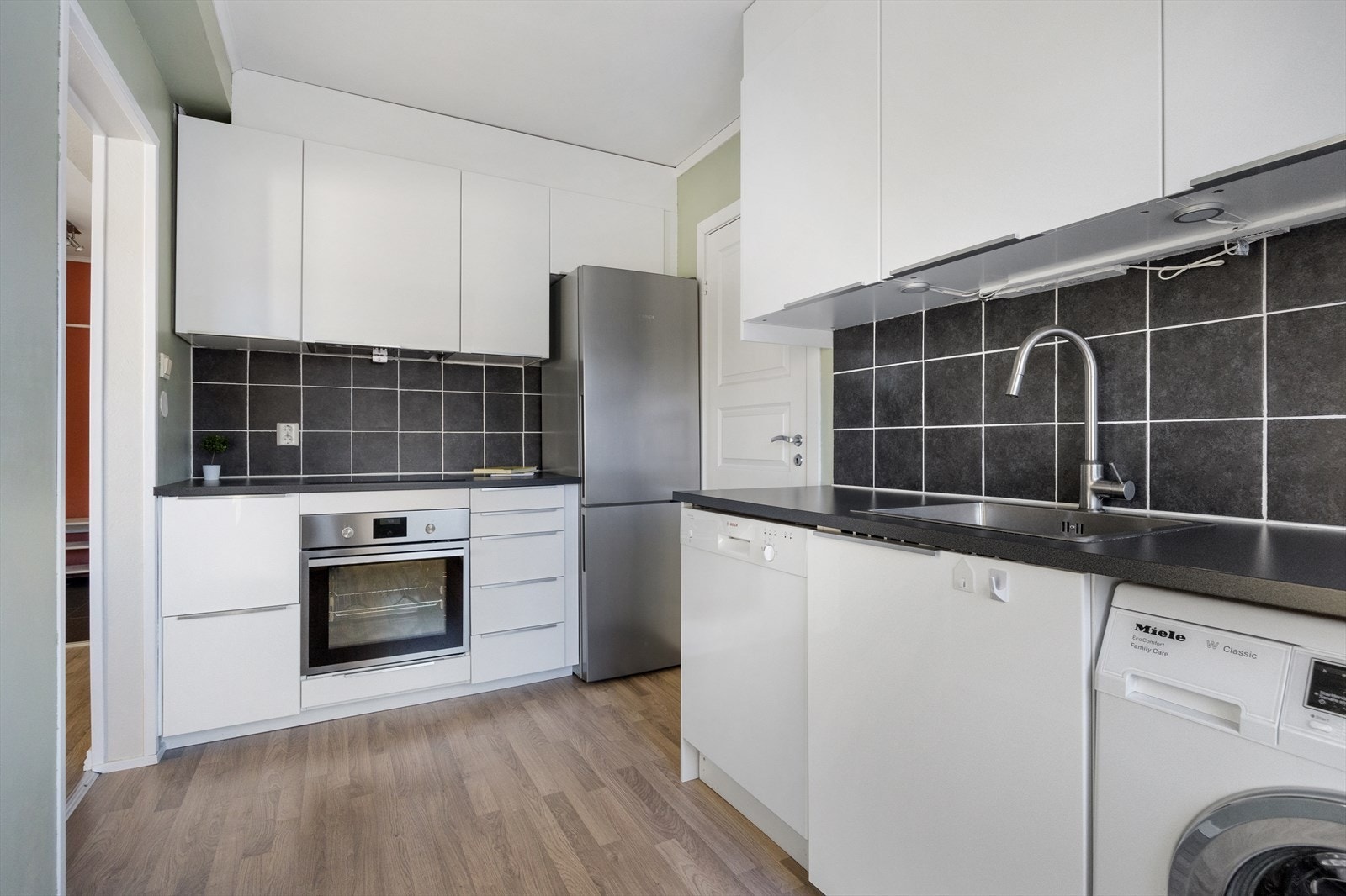 Kjøkkeninnredningen består av glatte fronter og laminat benkeplate med nedfelt stålvask. Galleribilde