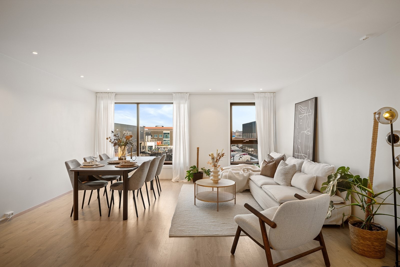 Lys stue med store vindusflater - god plass til både sofagruppe og spisebord Galleribilde