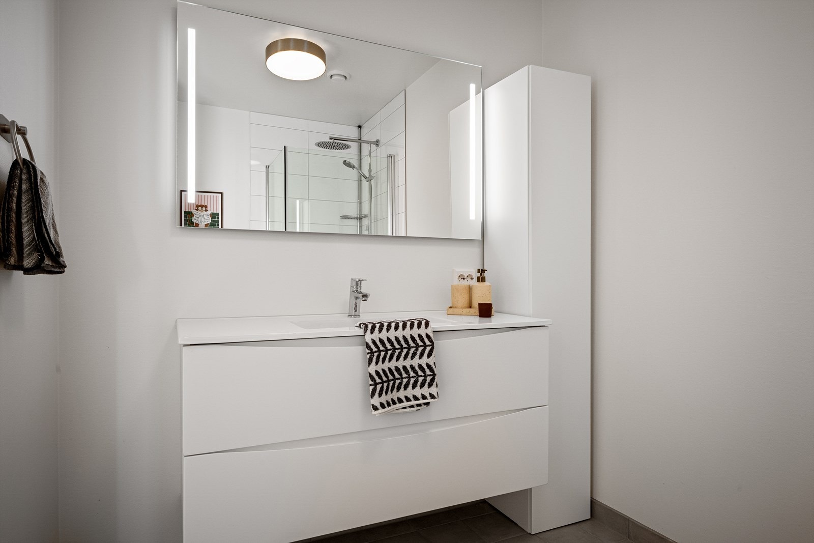 Badet i 2. etasje. Fliser og gulv og vegger i dusj. Hvit seksjon med vask/benk. Dusjhjørne og vegghengt toalett. Galleribilde