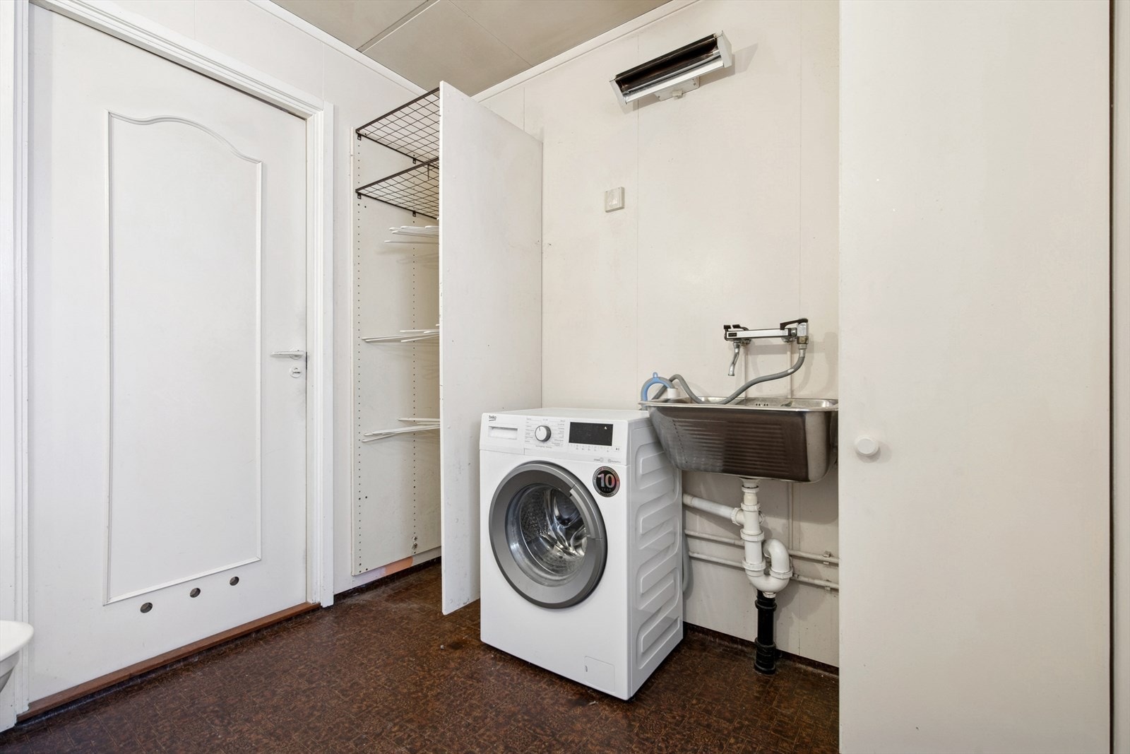 Rommet er innredet med en servant med underskap, speil, et gulvmontert toalett, dusjnisje og et dusjkabinett. Det er også opplegg for vaskemaskin. Galleribilde