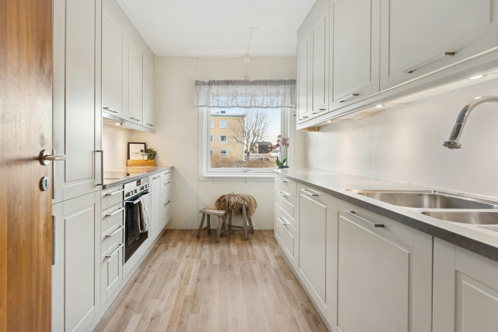 Kjøkken med profilerte fronter, laminat benkeplate og integrerte hvitevarer. Galleribilde