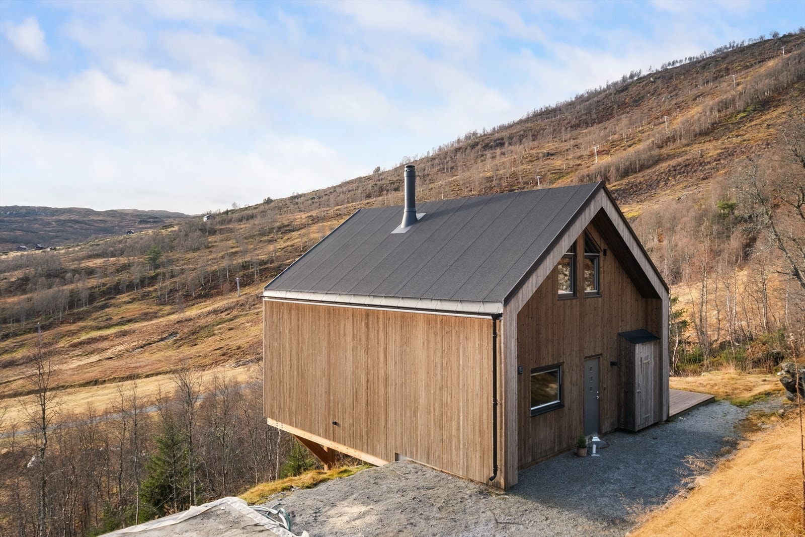 Utomhus framstår eigedomen/fellesarealet grovplanert, internvegar og parkeringsplassar er opparbeida med grus. Galleribilde