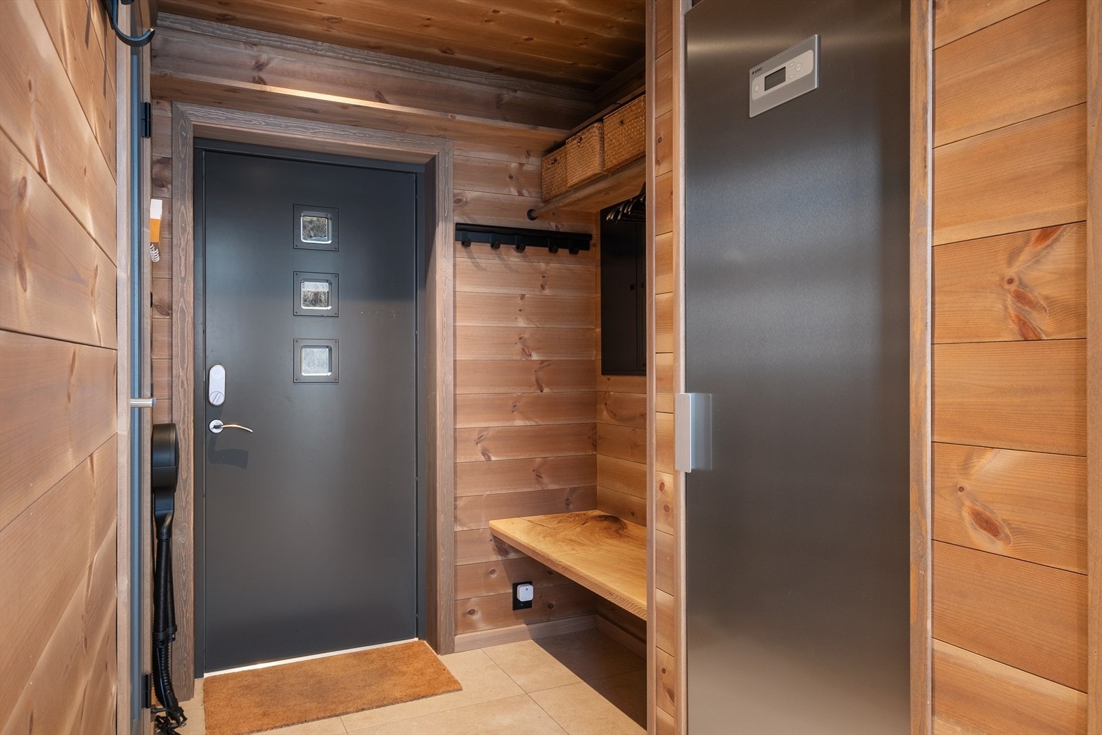 Entré med praktisk hylle, plass til oppheng av ytterklede, sittebenk frå Timbla og tørkeskåp. Flis på golv og elektrisk golvvarme. Galleribilde