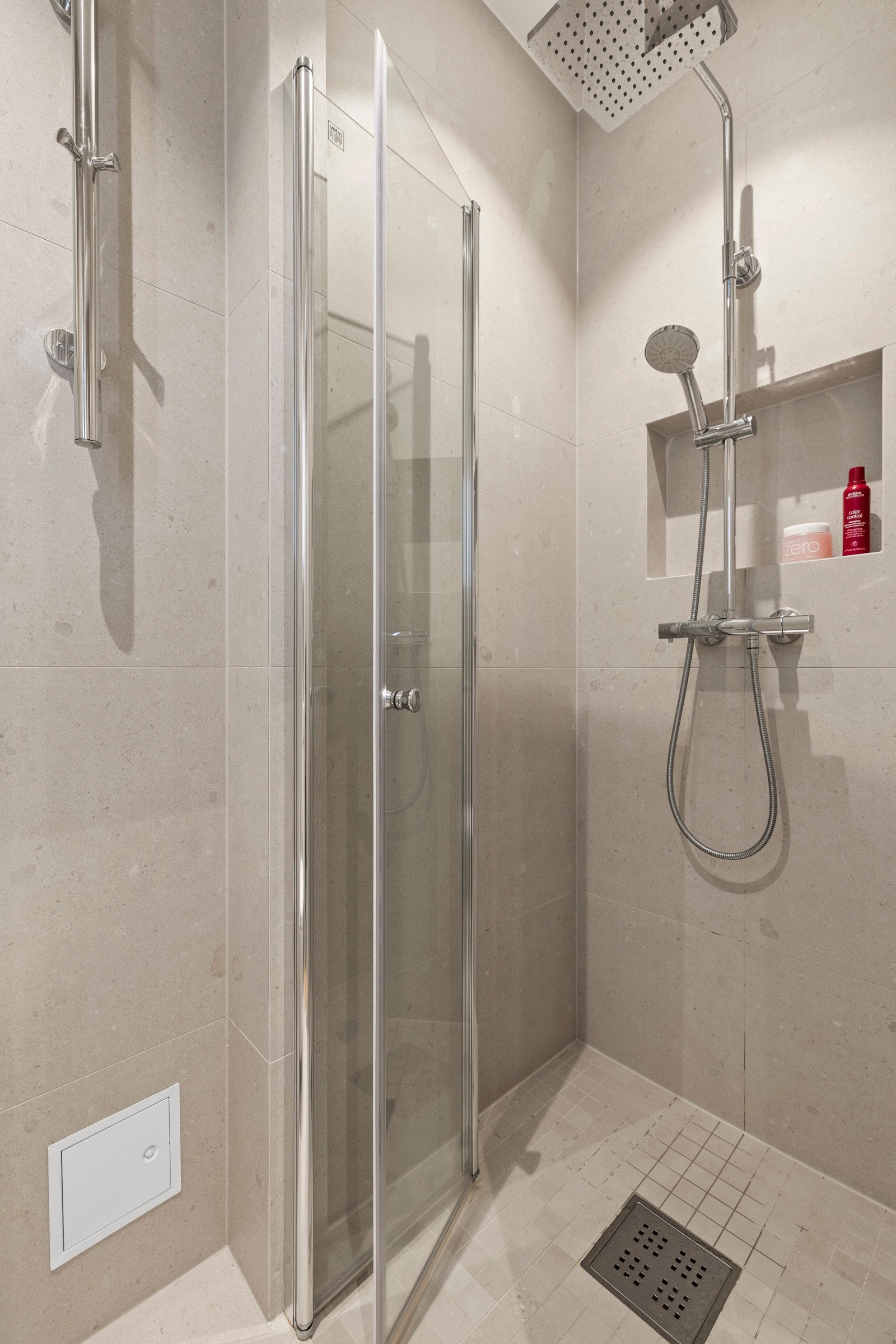 Her er det lagt vekt på funksjonalitet og brukervennlighet med vegghengt toalett, servantinnredning med skuffer og et praktisk speilskap med belysning og integrert stikkontakt. Dusjhjørnet er utstyrt med elegante glassdører, og elektrisk styrt vifte. Galleribilde