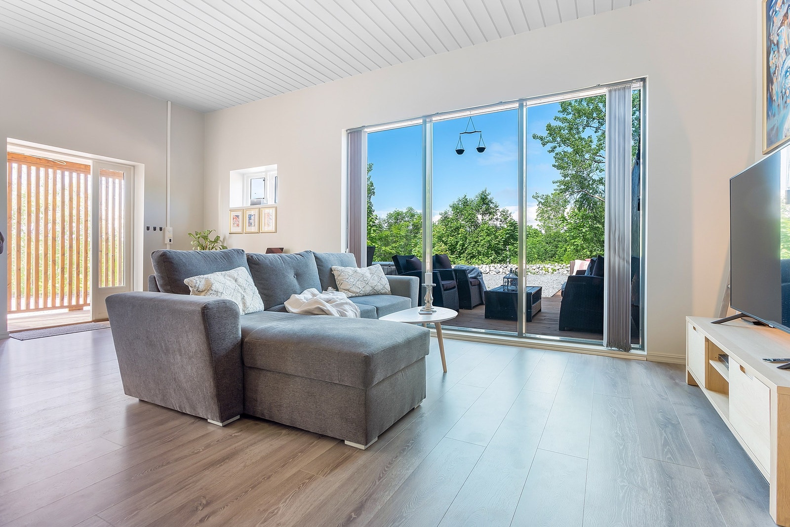 Stort rom innredet med sofa og tilhørende møblement. Galleribilde